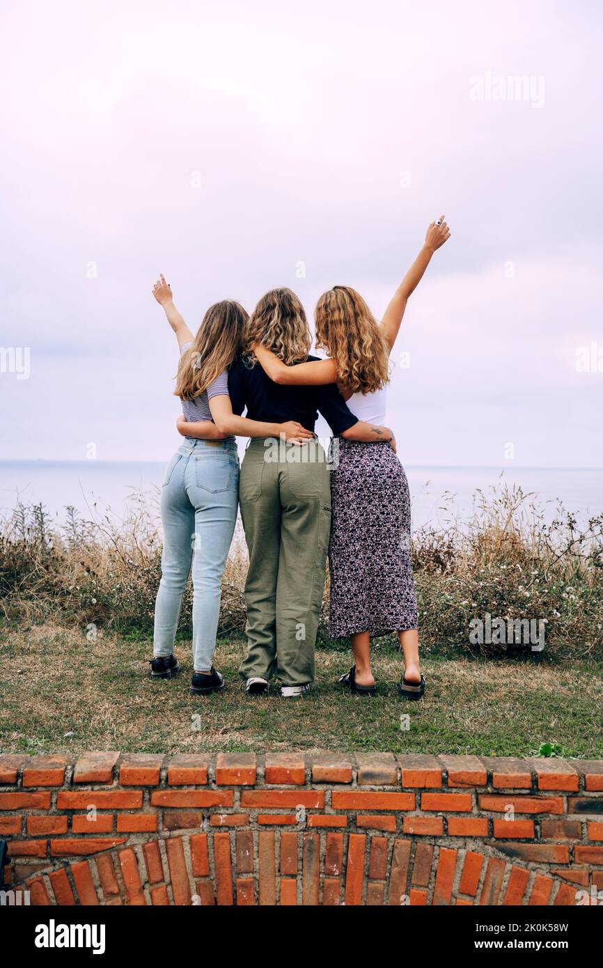 Cheerful smiling women hugging while standing in countryside Stock Photo