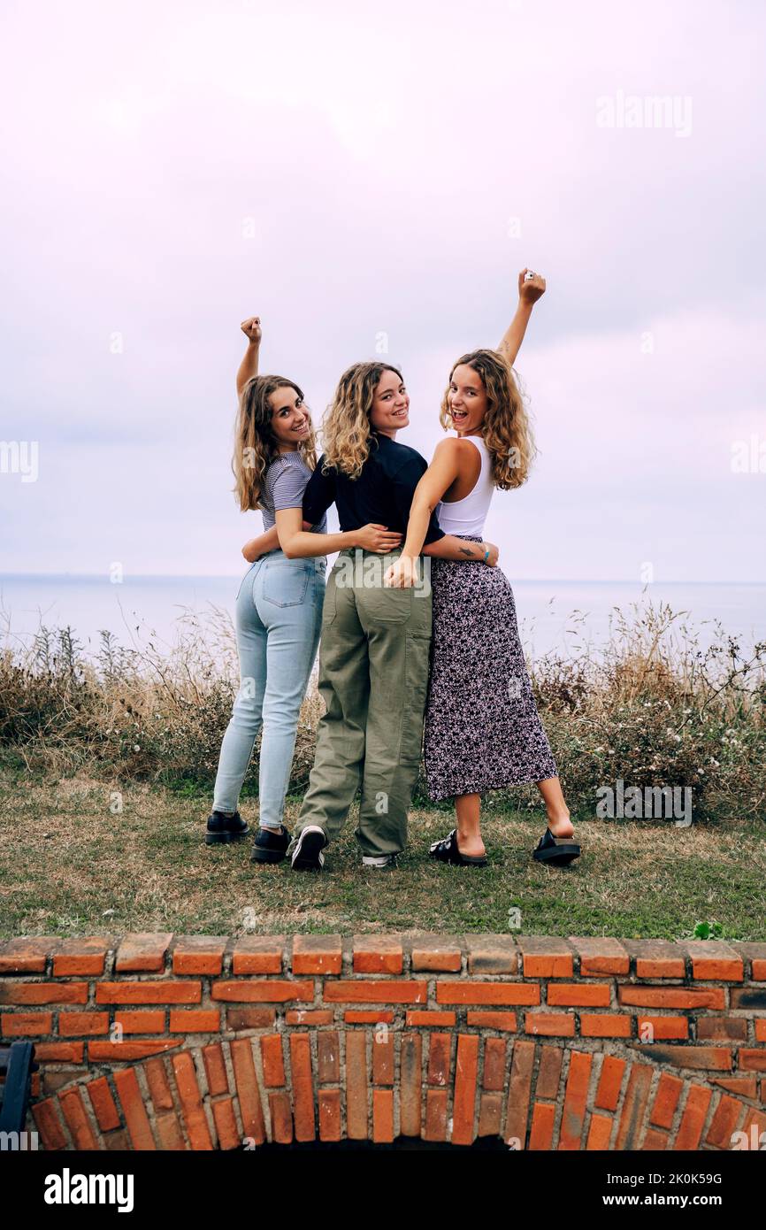 Cheerful smiling women hugging while standing in countryside Stock Photo