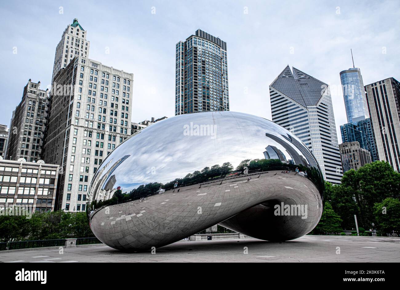The Bean (Cloud Gate) inside Chicago Millennium park, office buildings showing in the background. Stock Photo