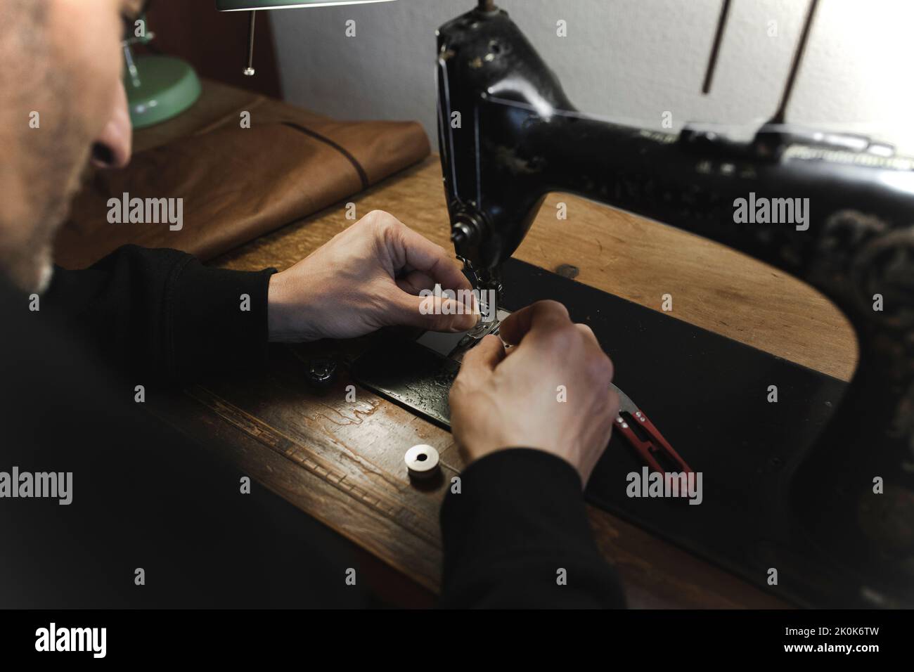 Man stitching textile in atelier Stock Photo