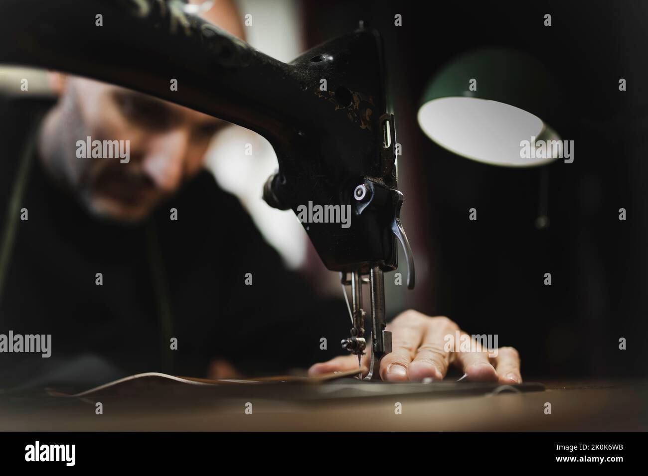 Man stitching textile in atelier Stock Photo