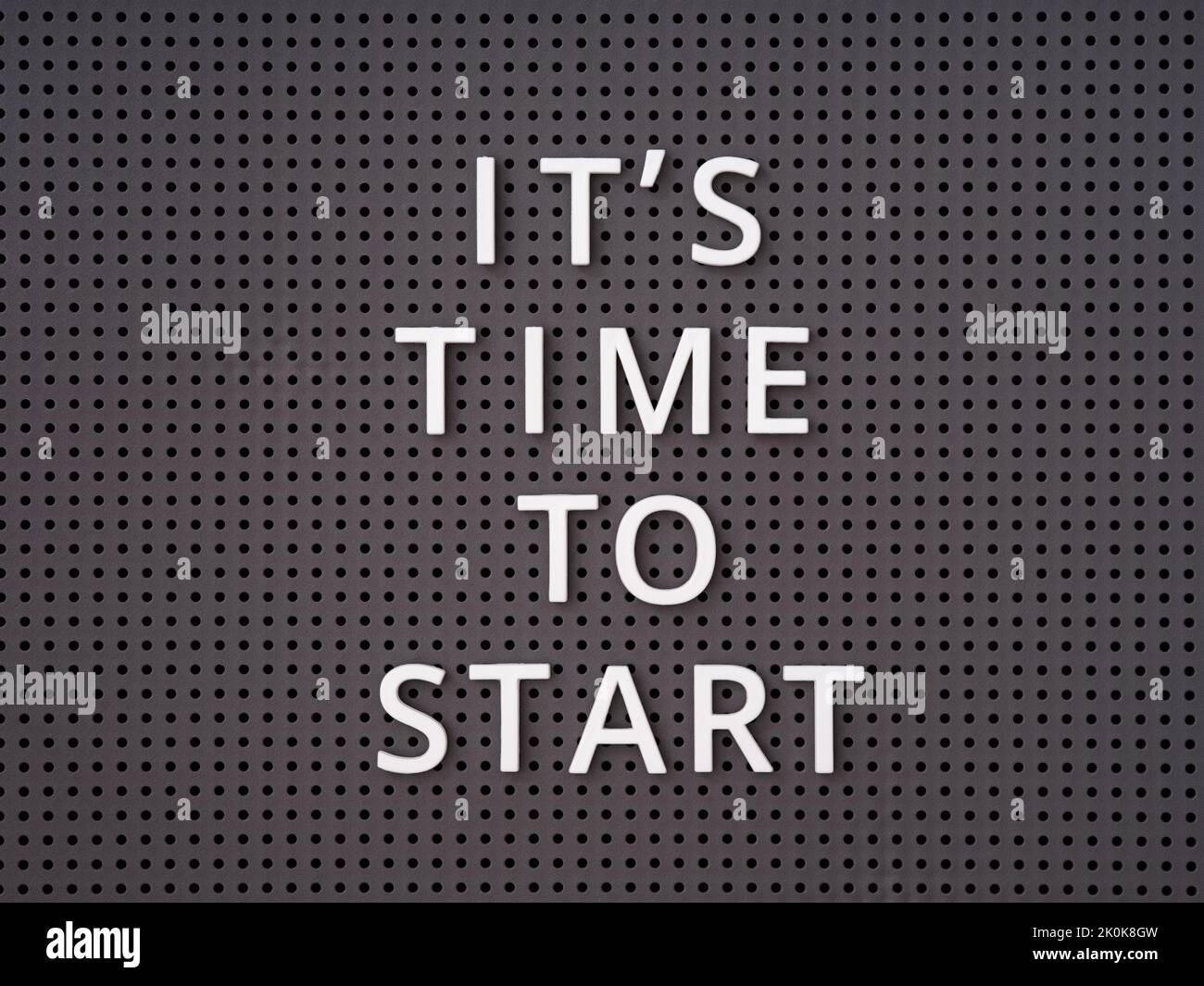 Phrase It is Time to Start spelled out with white letters on a gray pegboard Stock Photo