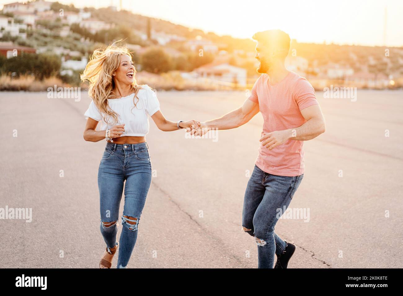 Cheerful man and excited woman looking at each other and laughing while ...