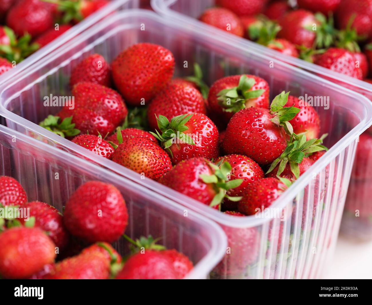 Some plastic containers full of ripe organic red strawberries Stock Photo