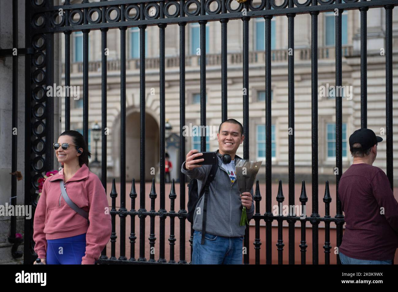 UK. 12th Sep, 2022. Mourners pose for photographs and selfies outside the gates of Buckingham Palace in London, UK on September 12, 2022. Queen Elizabeth II died on September the 8, 2022 at Balmoral Castle and is succeeded by her eldest son, King Charles III. (Photo by Claire Doherty/Sipa USA) Credit: Sipa USA/Alamy Live News Stock Photo