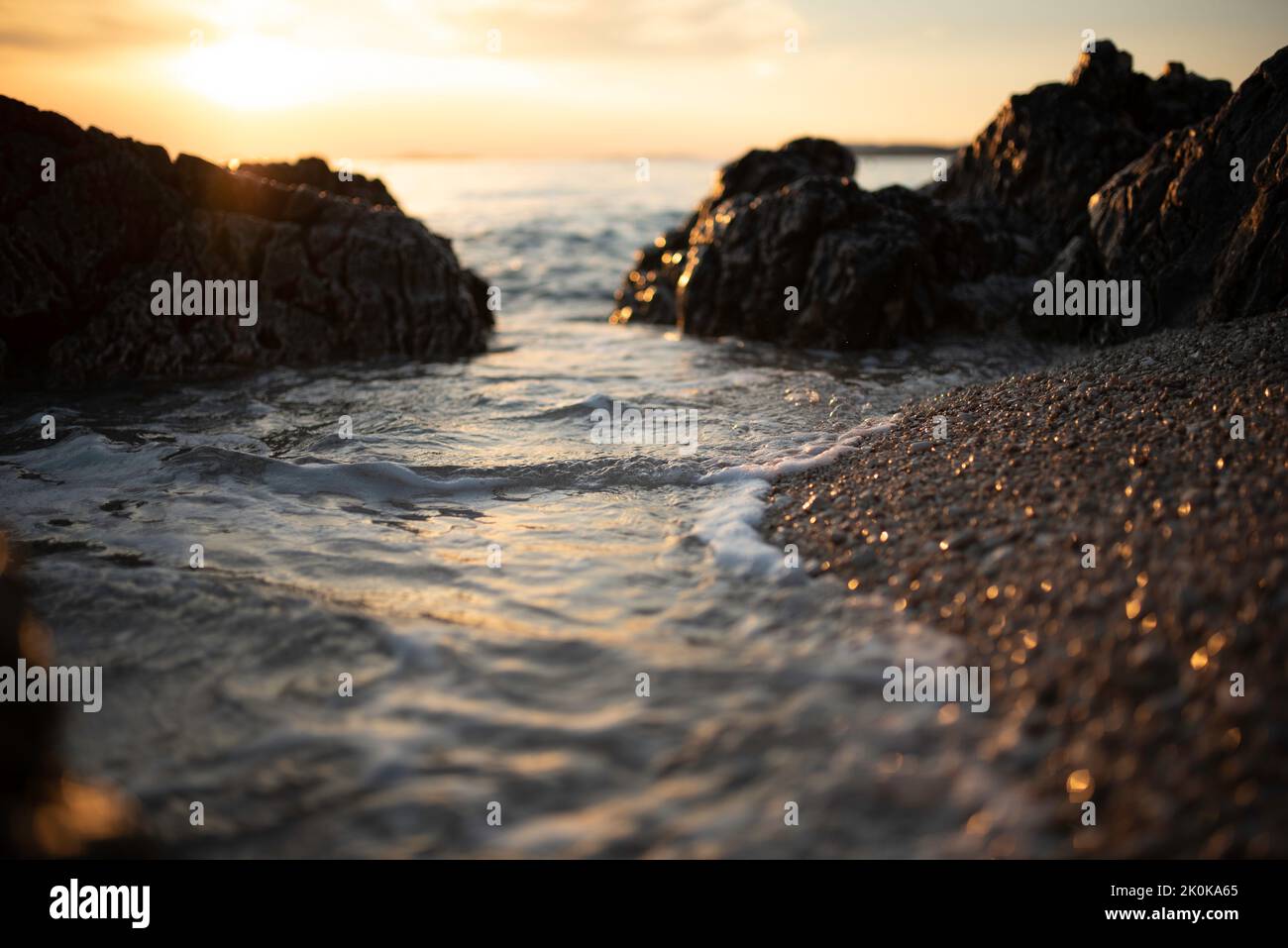 a closeup of rocks on a beach during a sunset Stock Photo - Alamy
