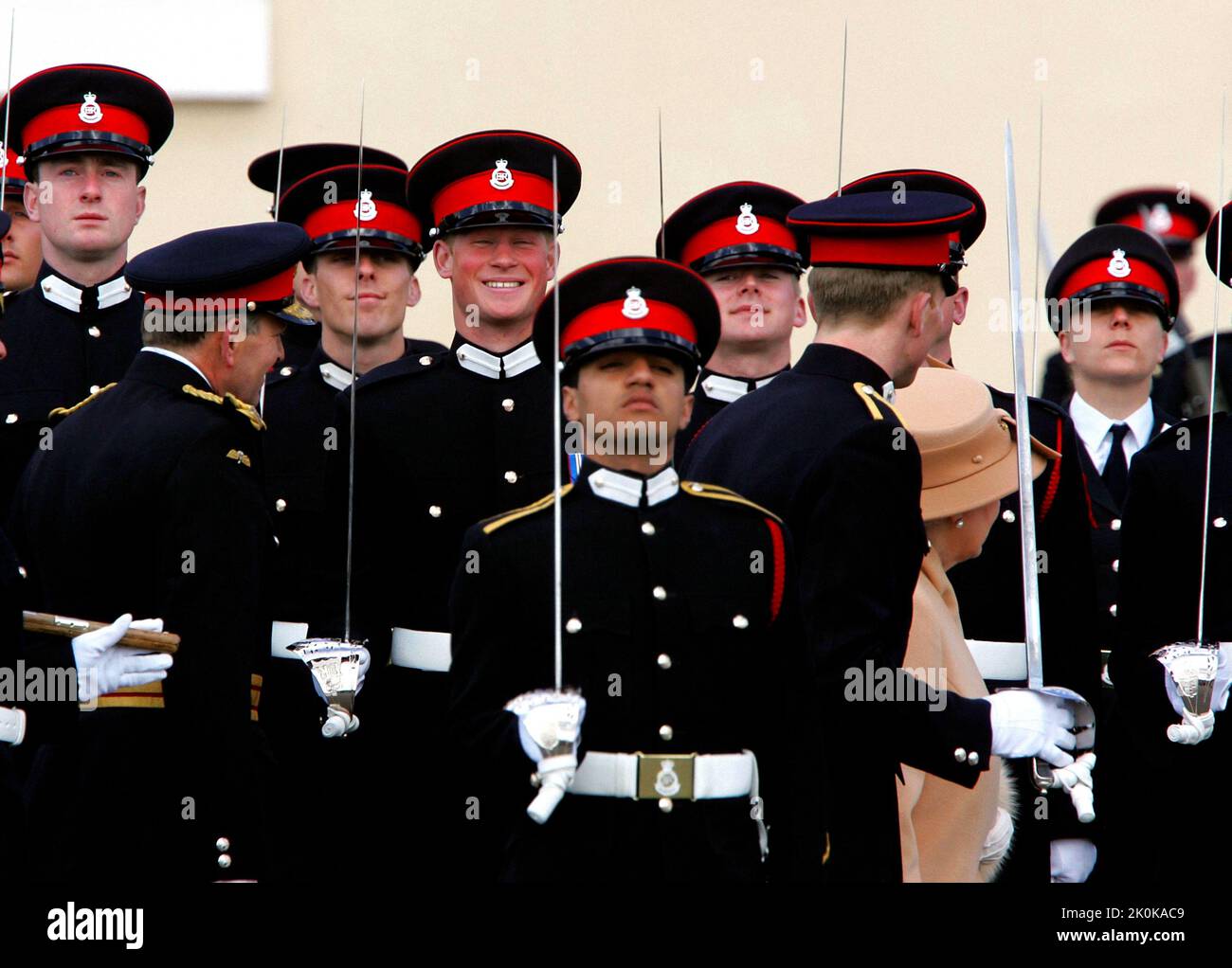 File photo dated 12/04/06 of Prince Harry (centre of frame) smiles broadly as his grandmother Queen Elizabeth II (partially hidden at right) reviews him and other officers during The Sovereign's Parade at the Royal Military Academy at Sandhurst in Surrey to mark the completion of their training. Issue date: Monday September 12, 2022. Stock Photo