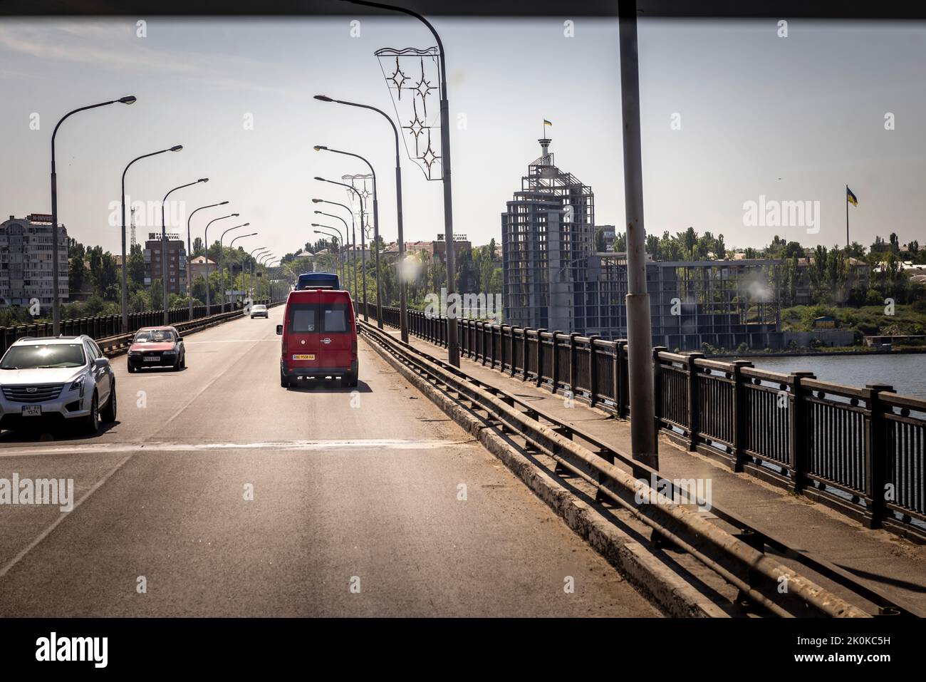 Auf der Brücke am Ortseingang nach Mykolajiw, welche immer wieder von russischen Angriffen getroffen wurde. Zwei Bussen fahren für die Evakuierung von rund 110 Flüchtenden in die Kampfzone im Oblast Mykolajiw. Die Flüchtenden werden zunächst nach Chisinau in Moldawien gebracht. Die Meisten wollen dann nach Deutschland weiterreisen. Stock Photo