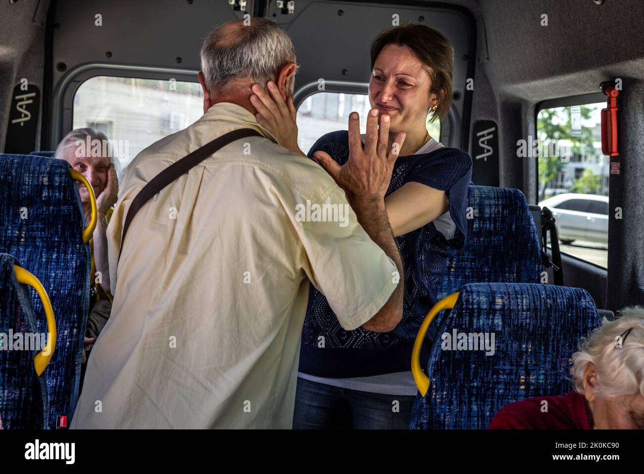 Two buses have arrived from Chisinau in Moldova at a refugee collection point in the center of embattled Mykolaiv in Ukraine to evacuate 110 refugees from the combat zone in Mykolaiv and the surrounding area. Here there are tearful farewell toasts before the journey can begin, first to Chisinau in Moldova. Most of them then want to continue their journey to Germany. Stock Photo