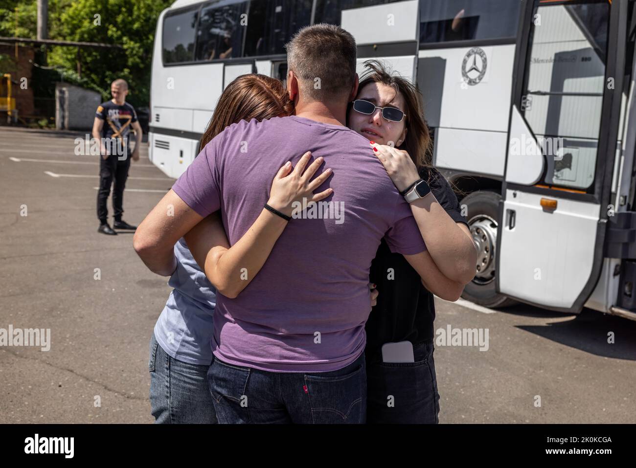 Two buses have arrived from Chisinau in Moldova at a refugee collection point in the center of embattled Mykolaiv in Ukraine to evacuate 110 refugees from the combat zone in Mykolaiv and the surrounding area. Here there are tearful farewell toasts before the journey can begin, first to Chisinau in Moldova. Most of them then want to continue their journey to Germany. Stock Photo