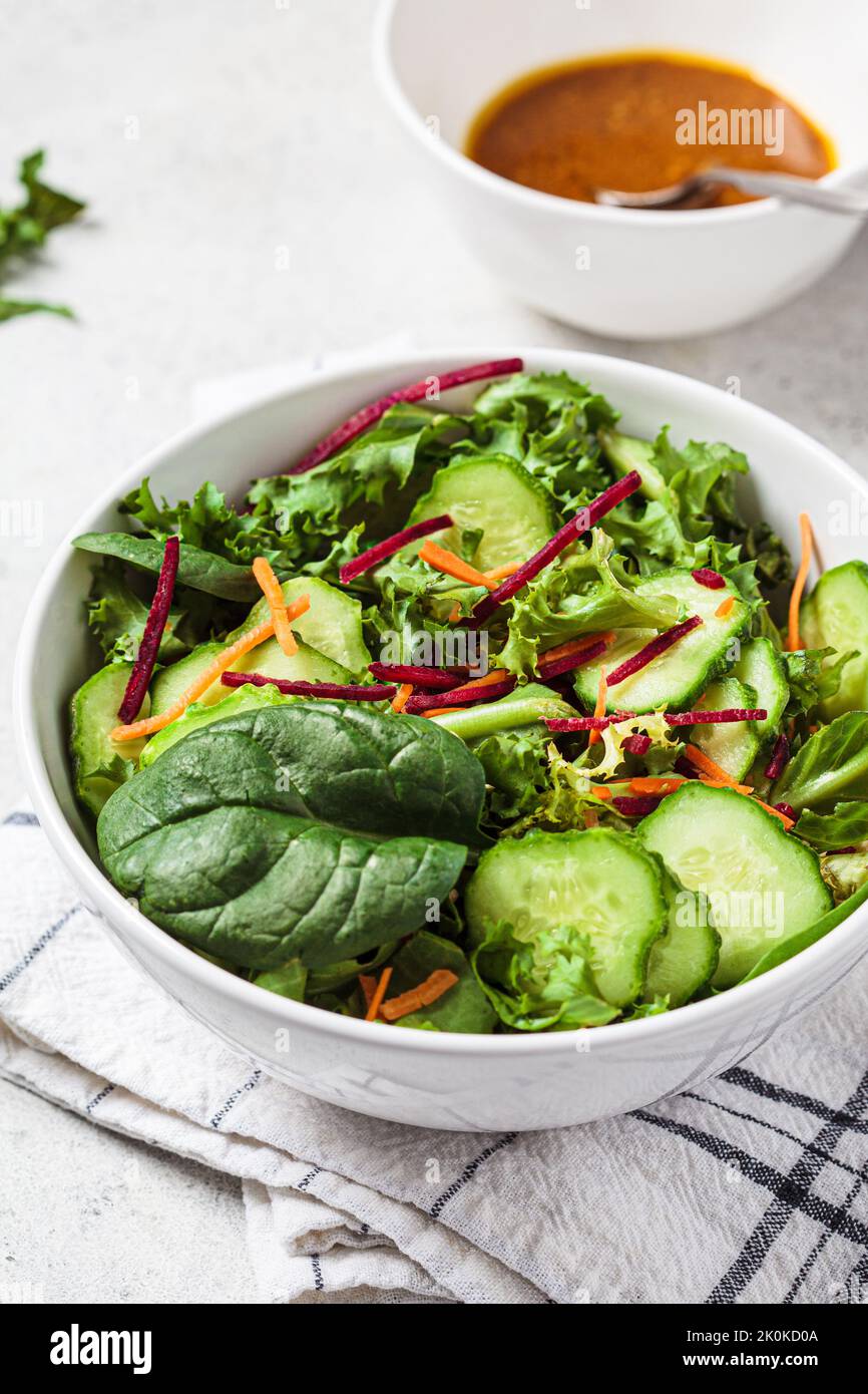 Green salad bowl with mustard dressing, close-up. Vegan food concept. Stock Photo