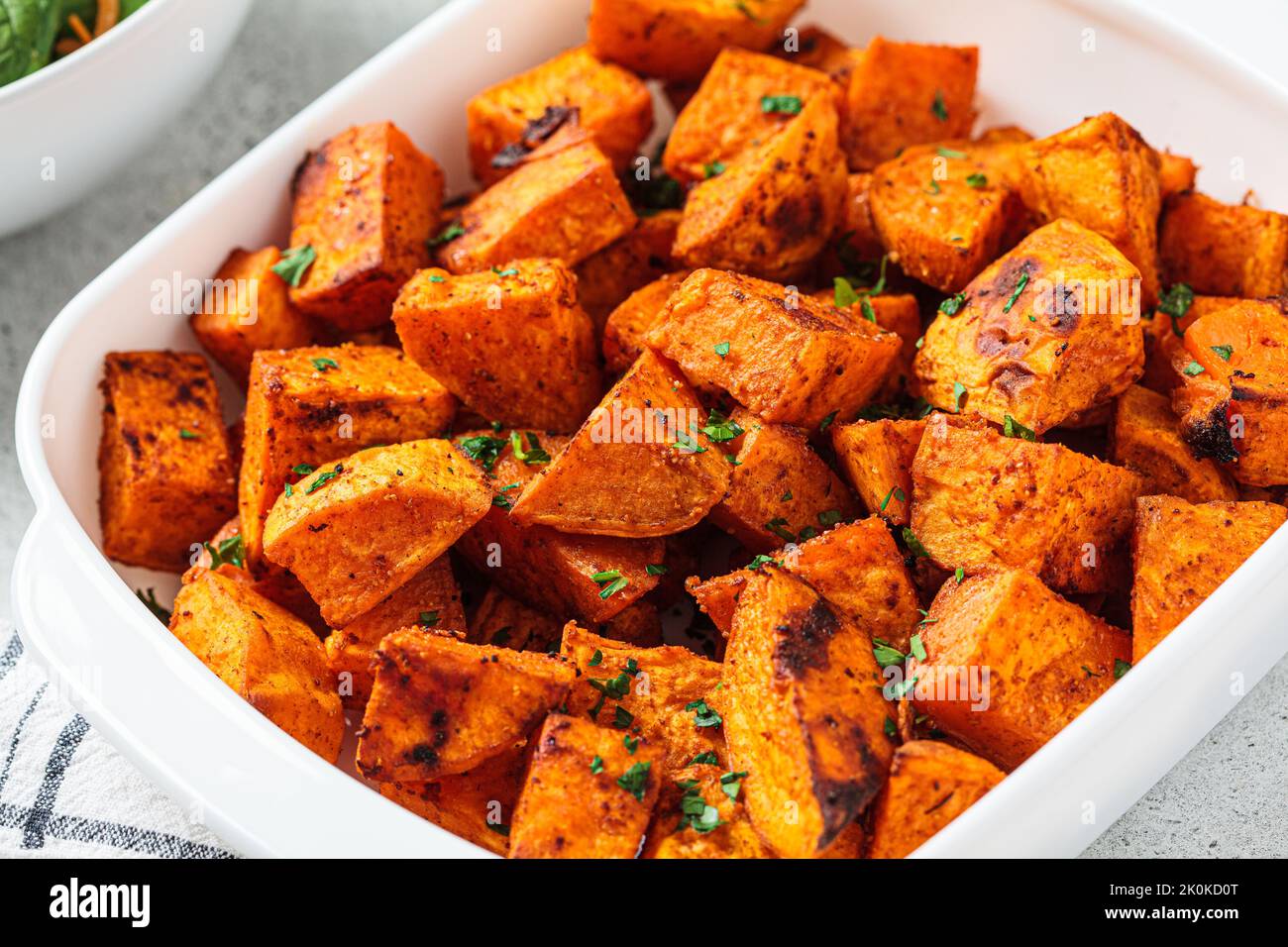 Crispy slices of baked sweet potato. Vegan food concept. Stock Photo