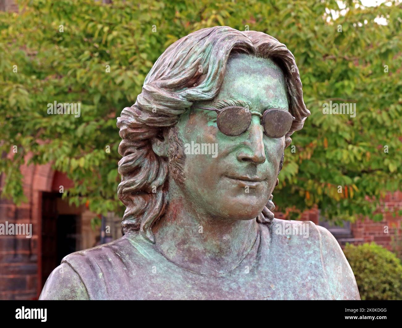John Lennon 'Imagine' peace sign bronze statue, by Laura Lian,at the foot of Penny Lane, St Barnabos Church, Liverpool, Merseyside, England, UK, L18 Stock Photo