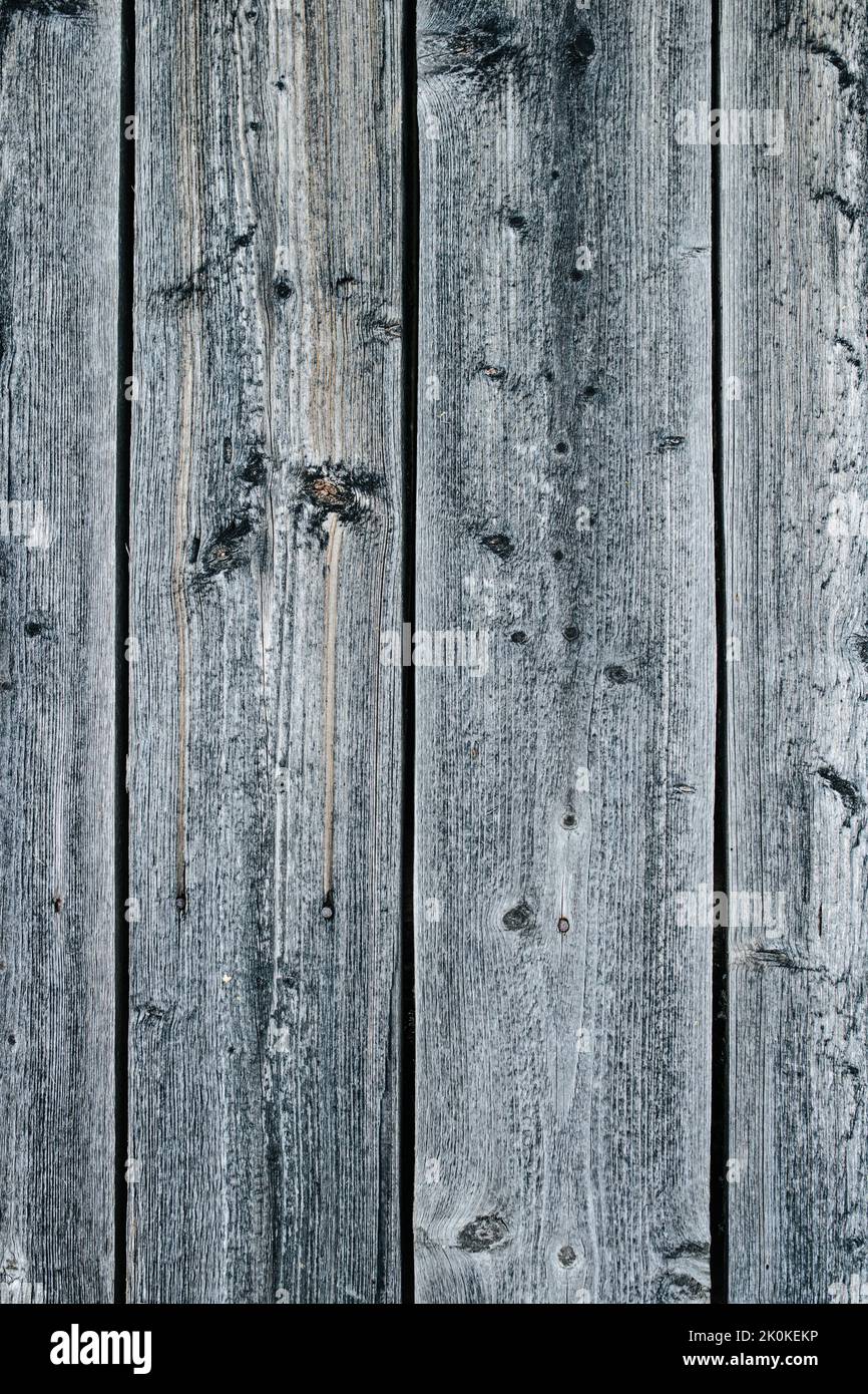 Vertical texture of grey weathered closely packed planks of a wooden fence Stock Photo