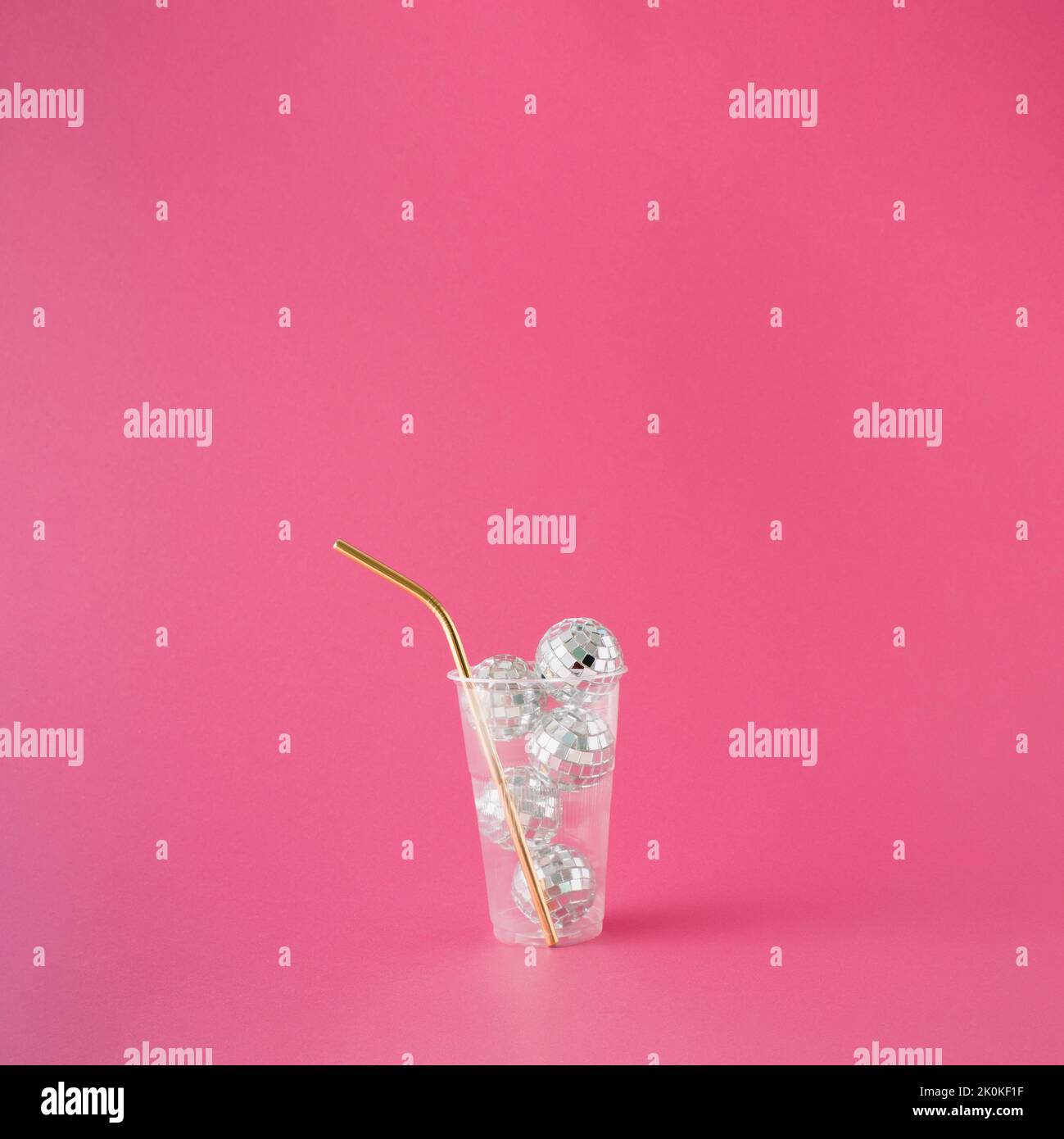 Transparent plastic drinking cup filled with shiny disco balls and