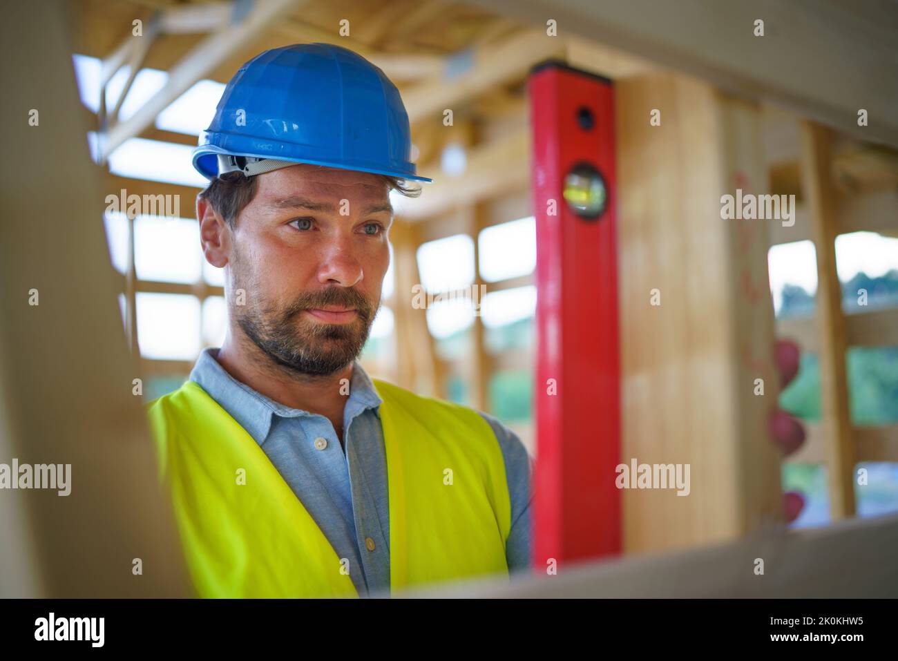 Carpenter checking wooden planks with spirit level, diy eco-friendly homes concept. Stock Photo