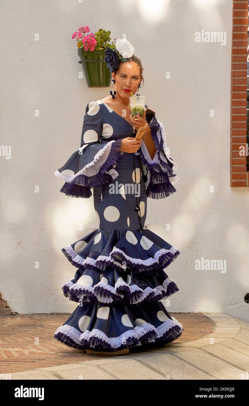 Spanish woman dressed in traditional flamenco dress during Feria, of Mijas, Andalucia, Spain. Stock Photo