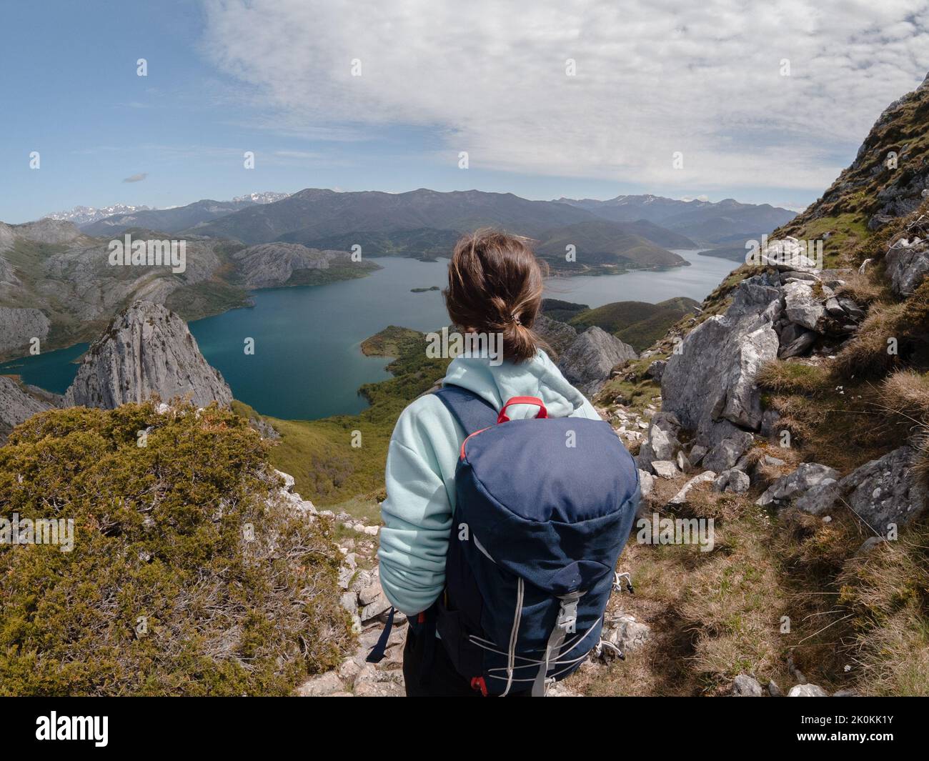 Back view of unrecognizable female hiker with backpack standing on hill ...