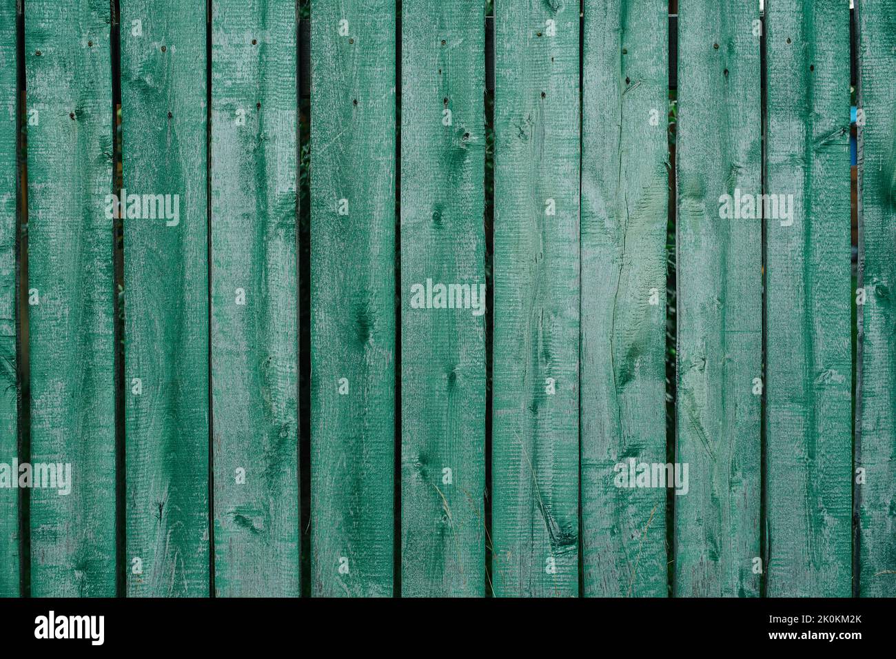 Lightly painted plank fence of green color texture. Attached with nails Stock Photo