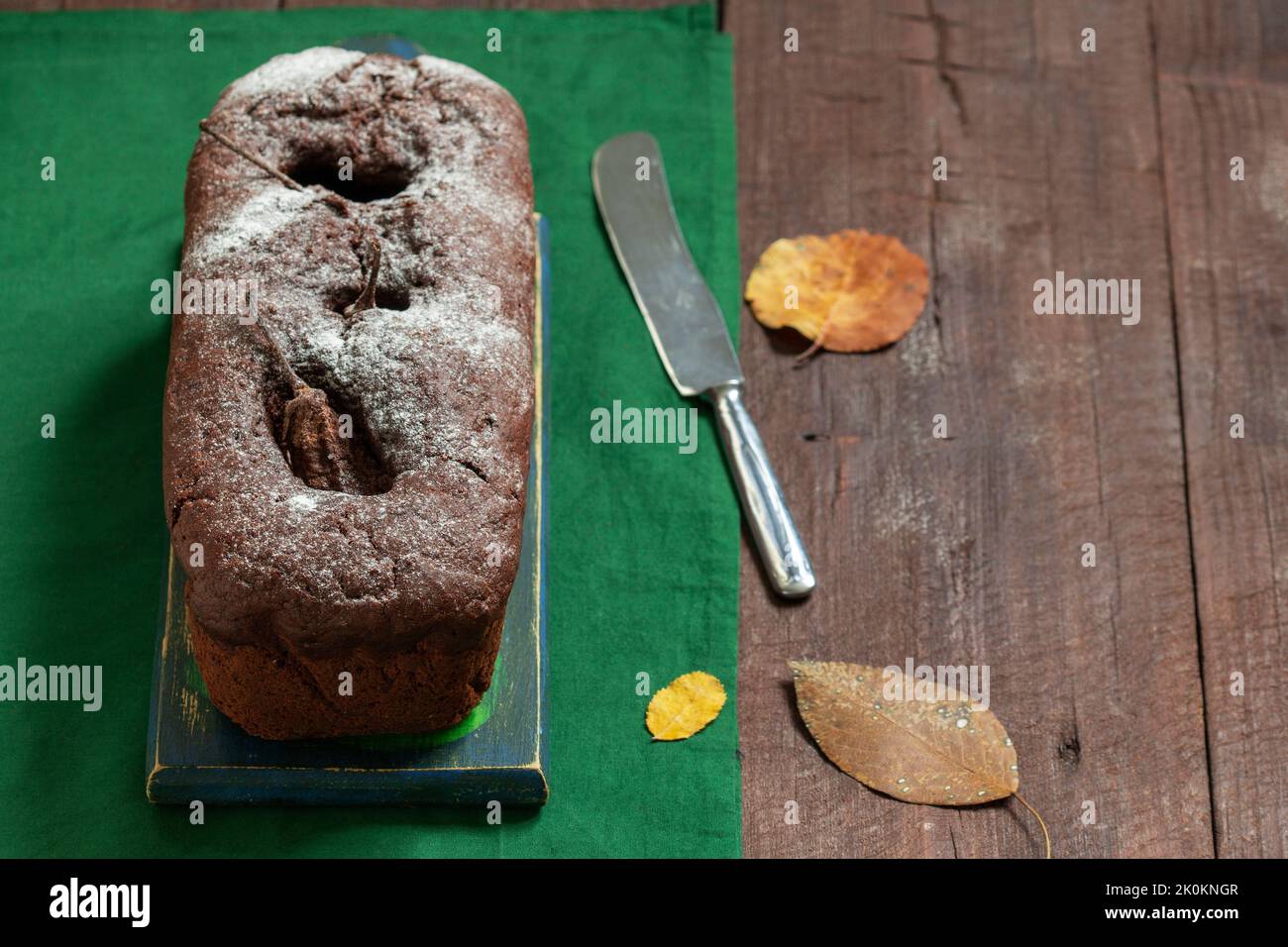 Chocolate pear cake on a green background. Rustic style. Stock Photo