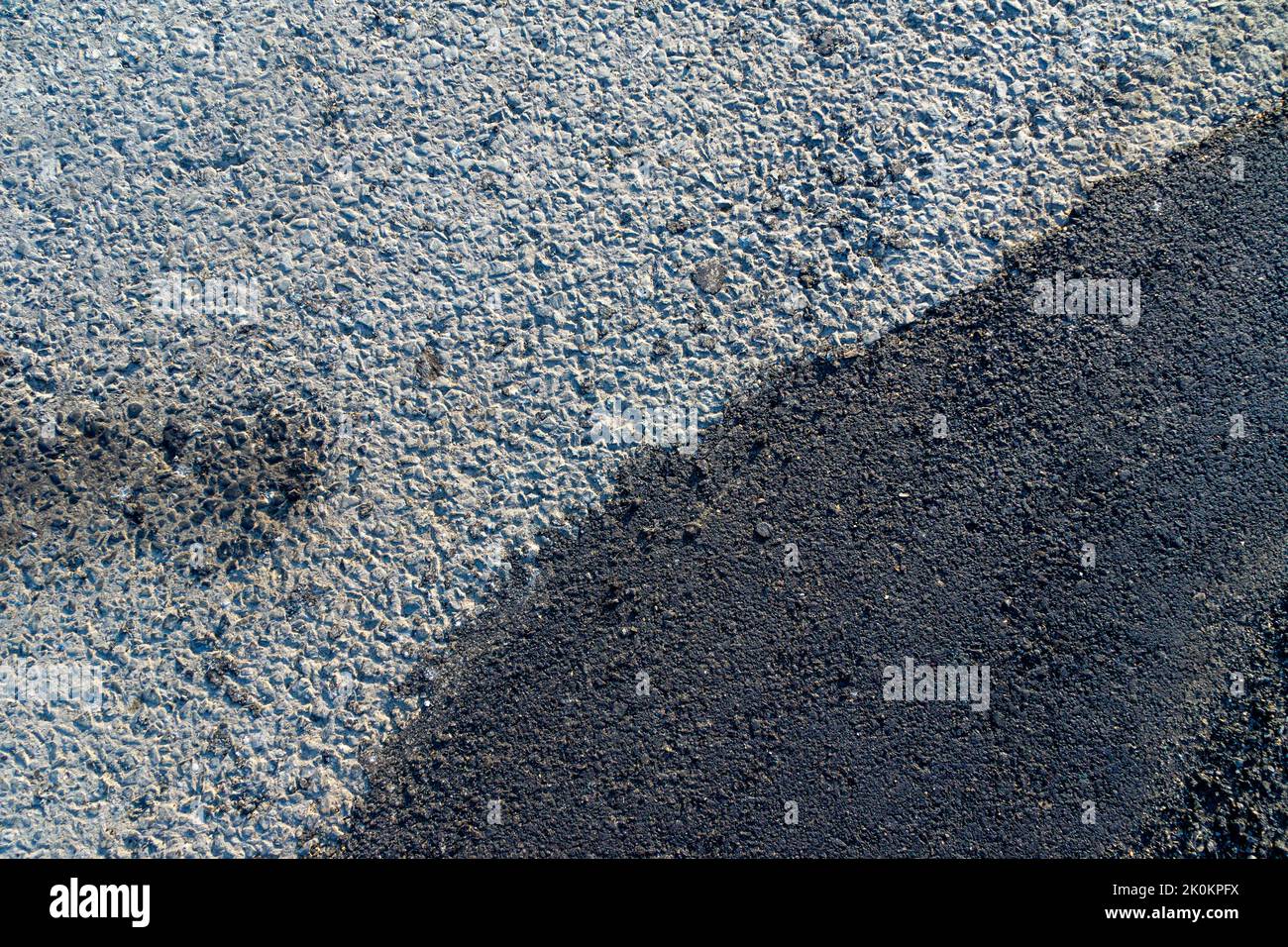 new asphalt is poorly compacted in the area of connection with the old asphalt surface, poor quality work on the restoration of the roadway Stock Photo