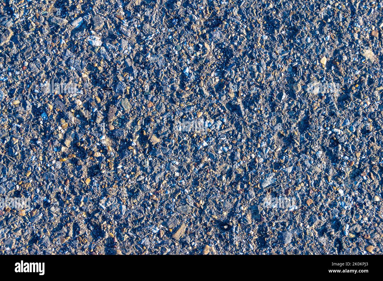 texture of old chipped asphalt with a cold bluish tint, selective focus Stock Photo