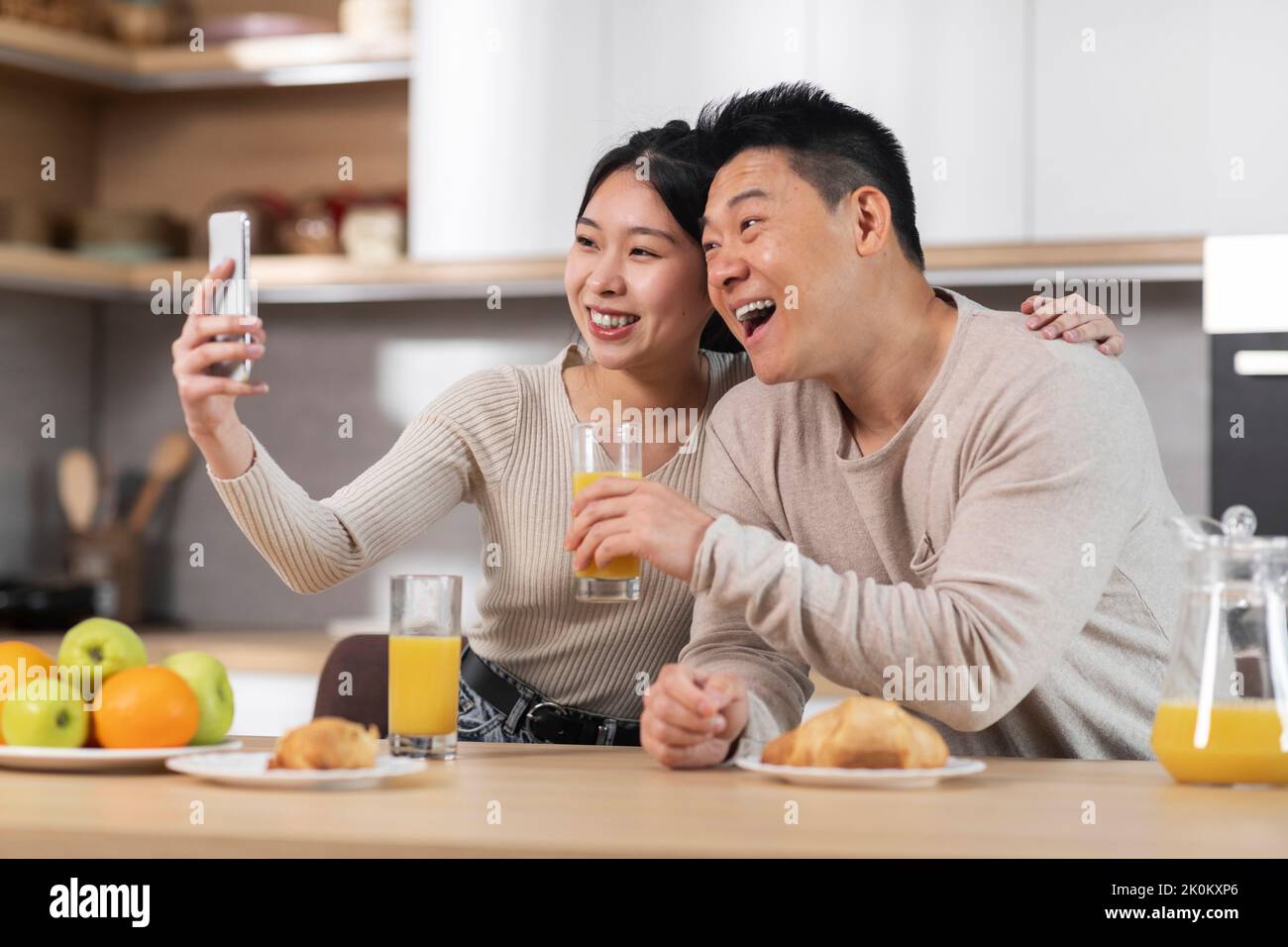 Cute asian couple taking selfie while having breakfast Stock Photo