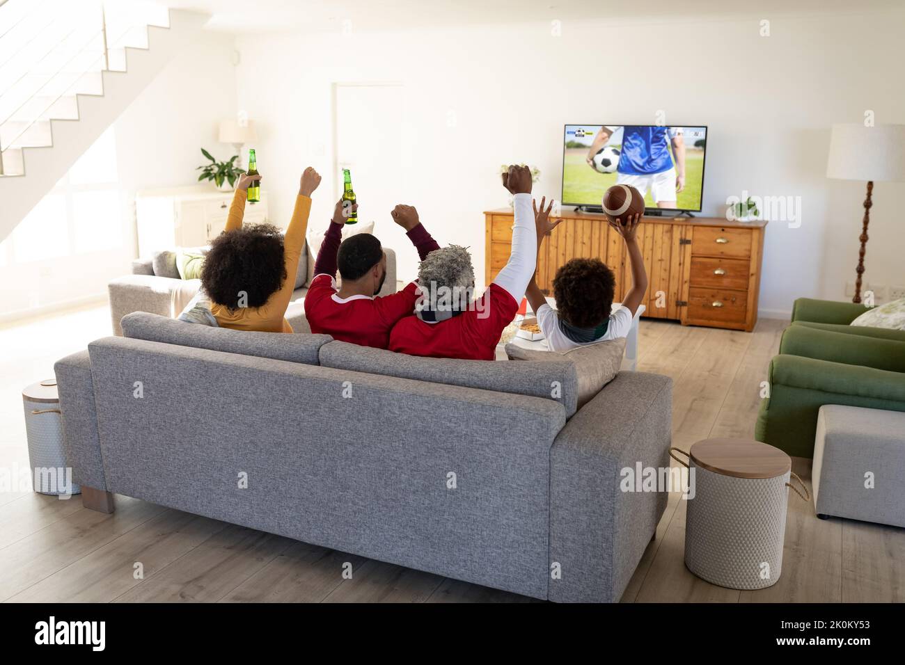 African american family sitting on the couch and watching football match on laptop Stock Photo