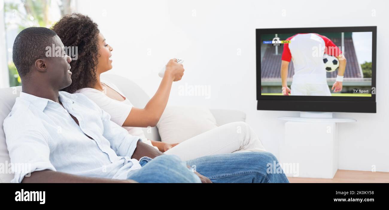 African american couple sitting on the couch and watching football match Stock Photo