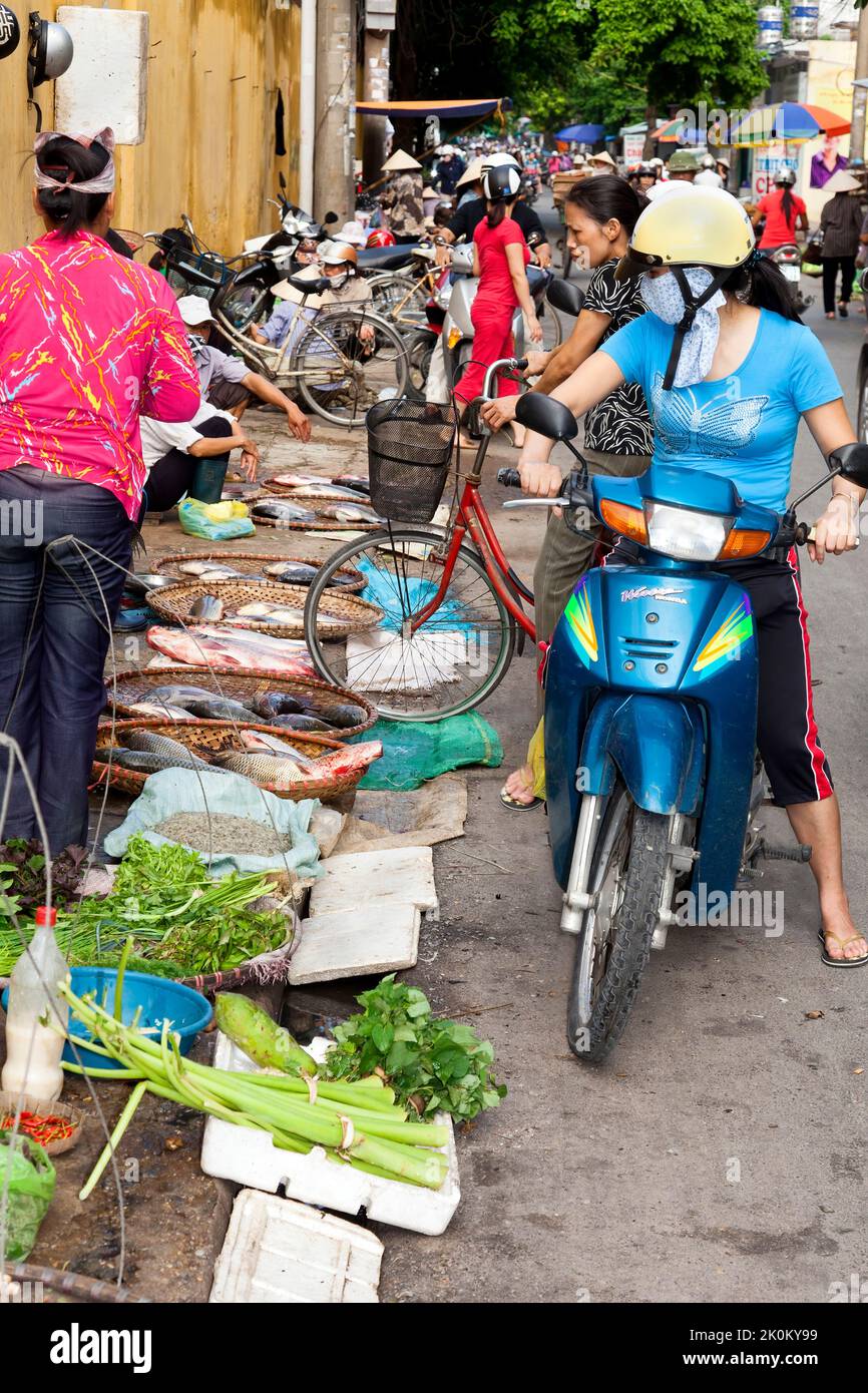 Vietnamese vendor wearing bamboo hat working in open air street market, Hai Phong, Vietnam Stock Photo