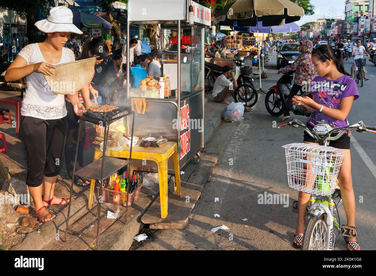 Vietnamese vendor cooking on barbeque in open air street market, Hai Phong, Vietnam Stock Photo