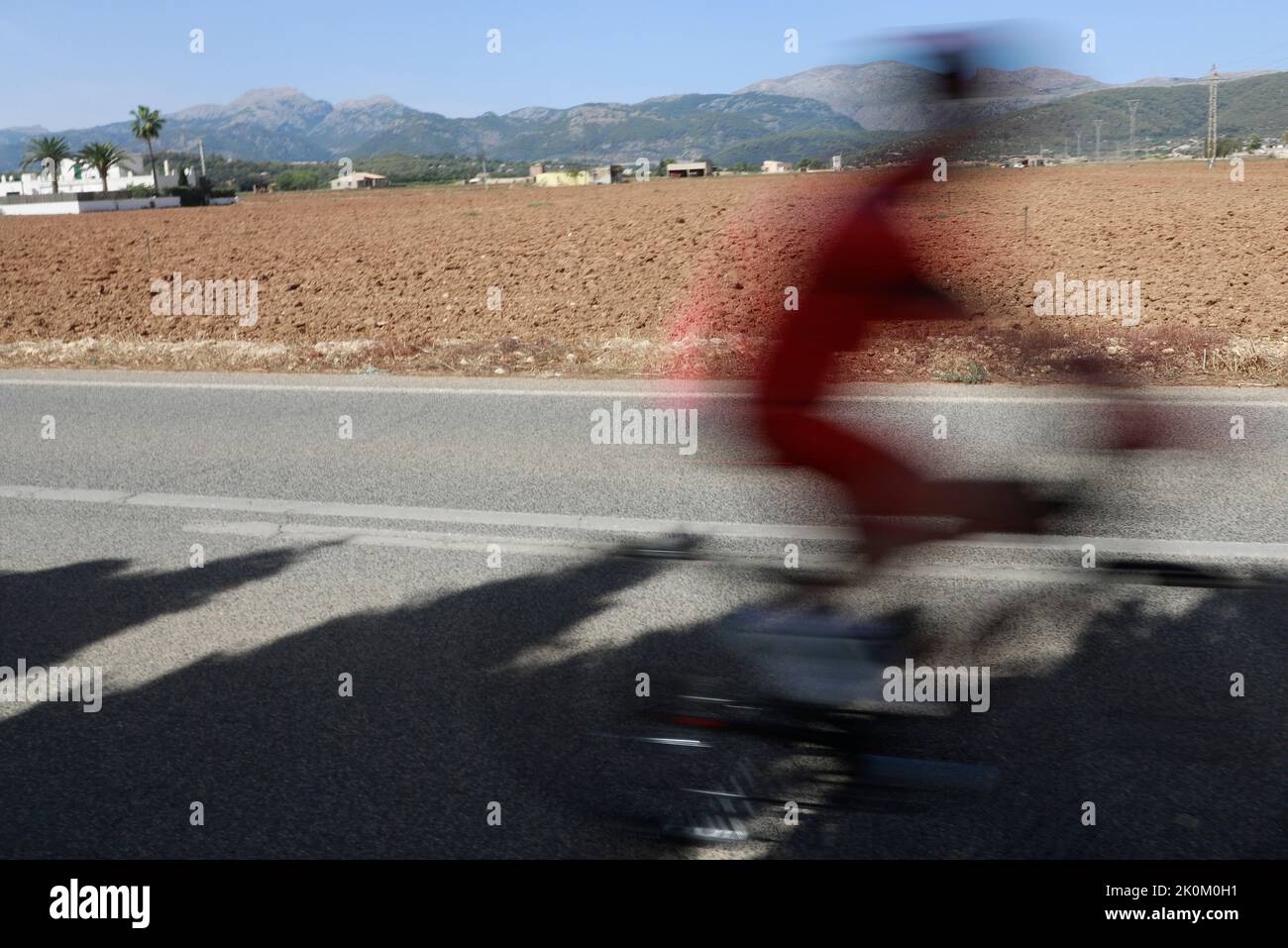 12 September 2022, Spain, Búger: A bicyclist rides next to a field during a heat wave and a yellow emergency warning for high temperatures after a summer of record highs. Photo: Clara Margais/dpa Stock Photo