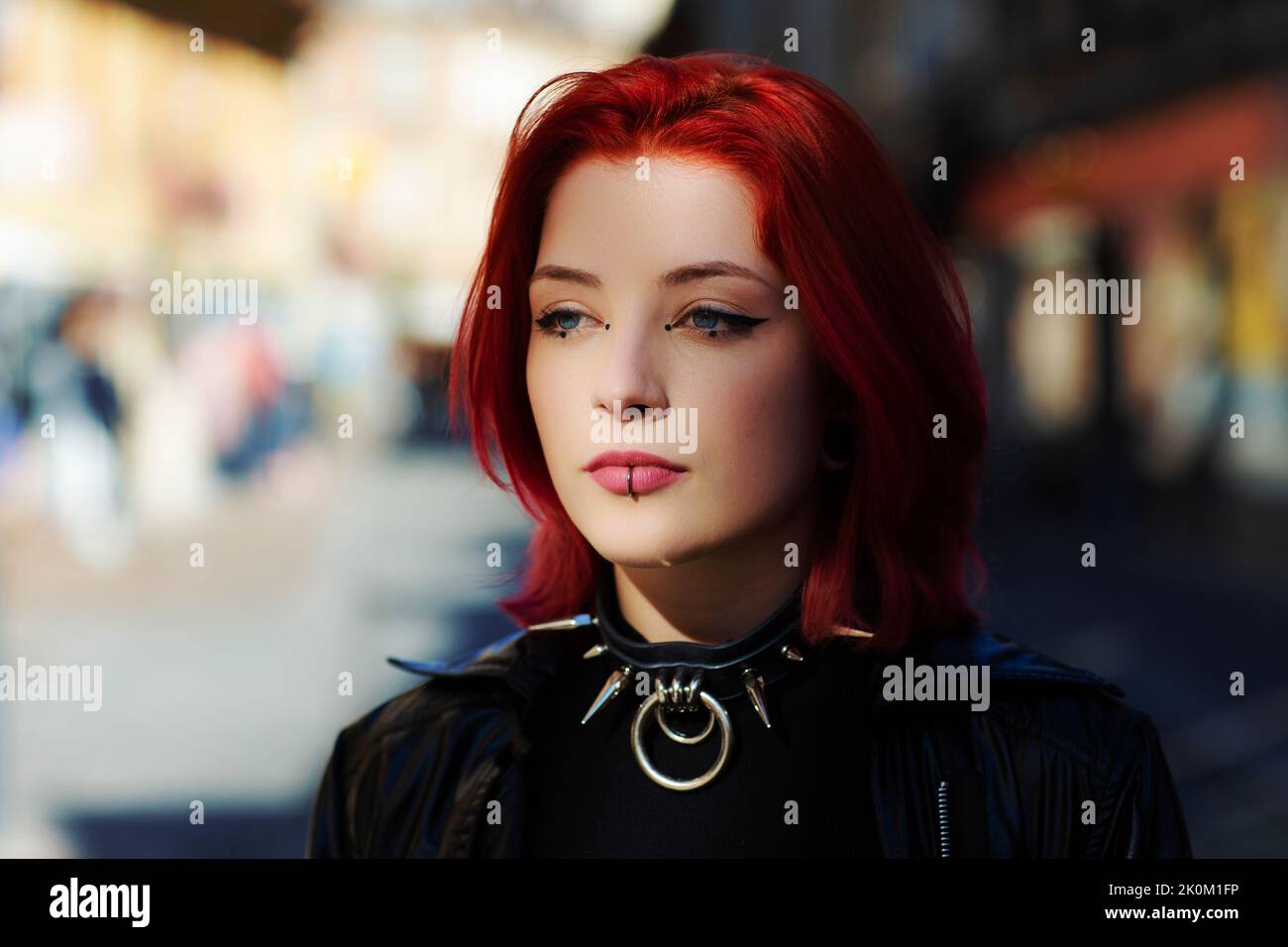 close up young adult woman outside blue eyes with punk spike choker Stock Photo