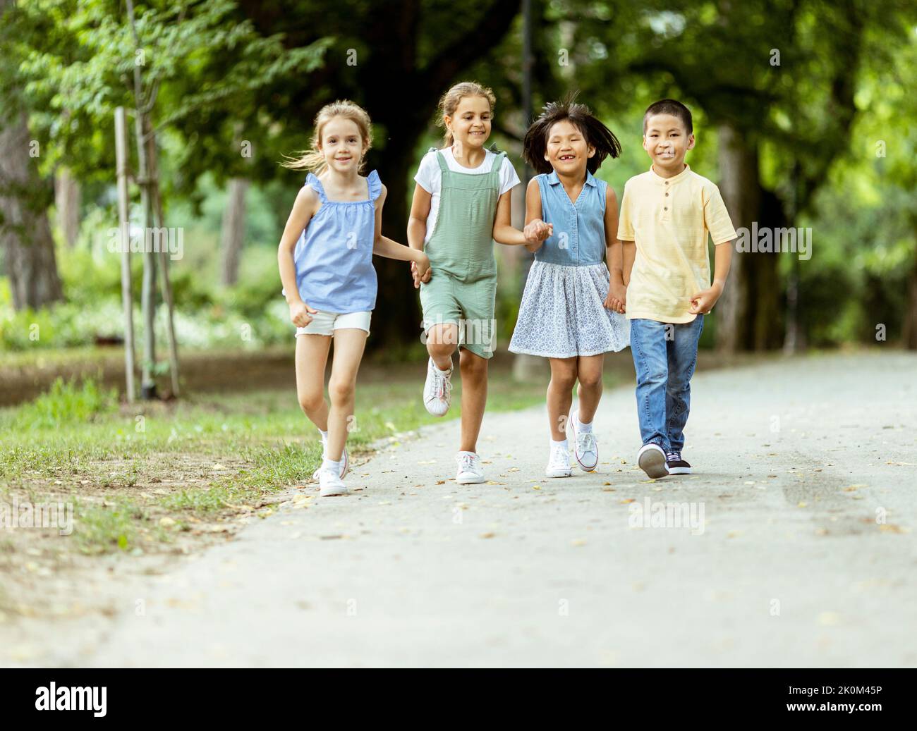 Group of cute asian and caucasian kids having fun in the park Stock Photo