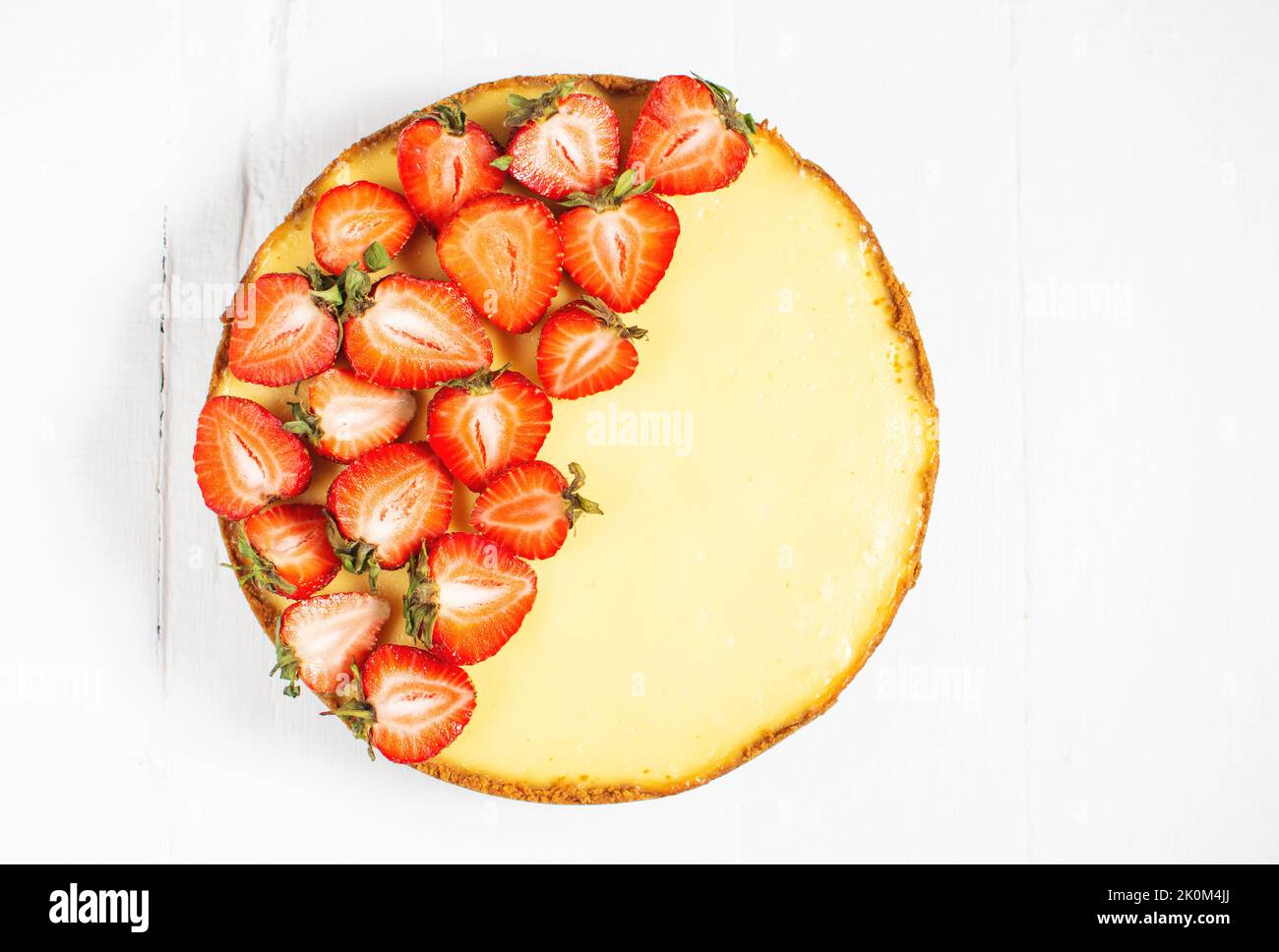 Sweet breakfast, delicious cheesecake with fresh strawberries, homemade recipe on white wooden table. Top view Stock Photo