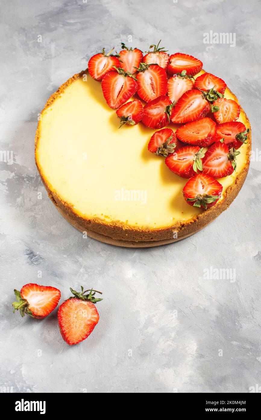 Sweet breakfast, delicious cheesecake with fresh strawberries, homemade recipe on concrete table. Stock Photo