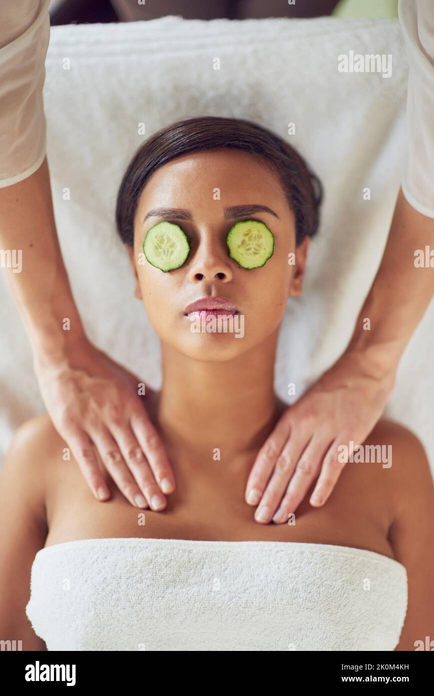 Getting the royal pampering she deserves. a young woman with cucumber slices over her eyes receiving a beauty treatment at a spa. Stock Photo