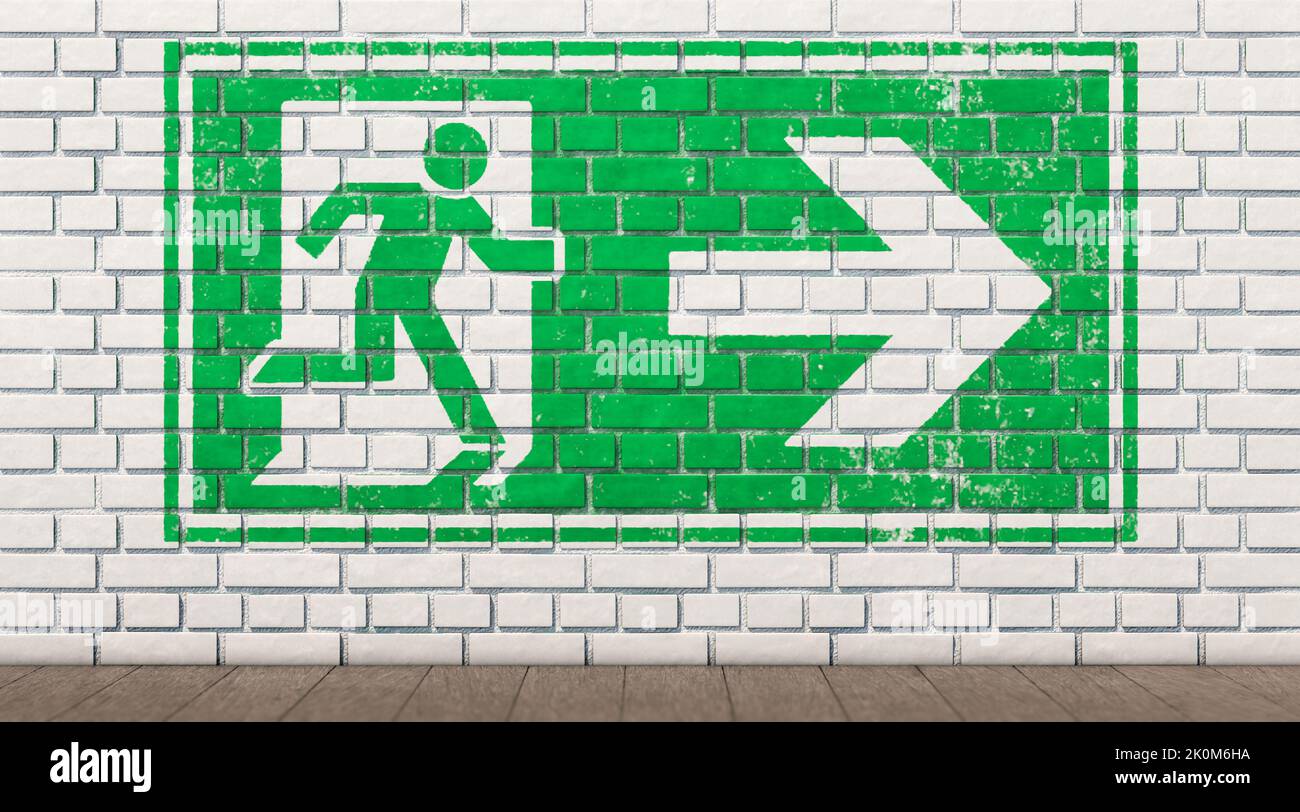 Exit sign on white brick wall Stock Photo