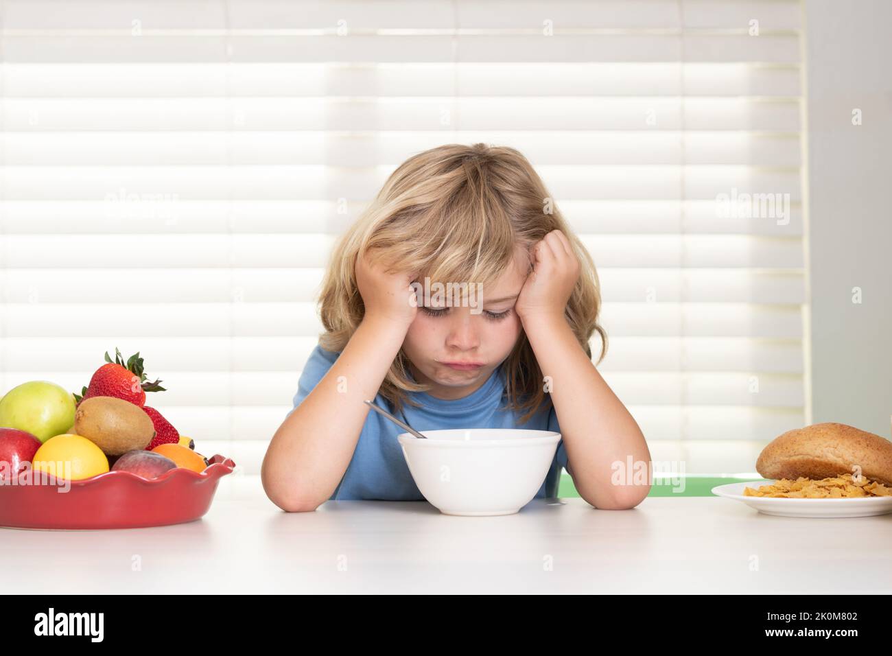Portrait of child with no appetite. Concept of loss of appetite. Kid bot eating meal. Healthy nutrition for children. Child enjoy eating for breakfast Stock Photo