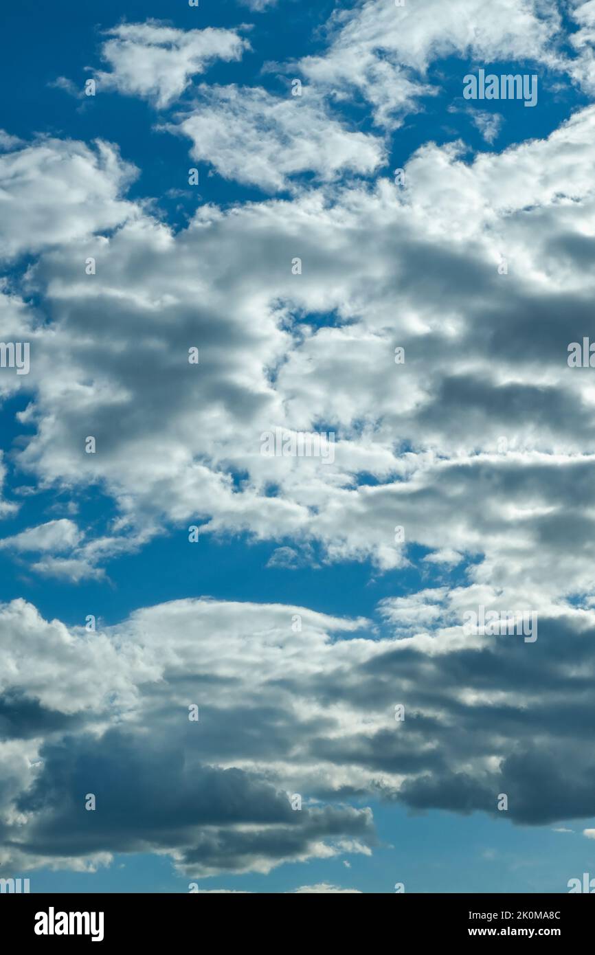 Blue sky with thunderclouds. The sun breaks through the clouds. Black clouds. Stock Photo