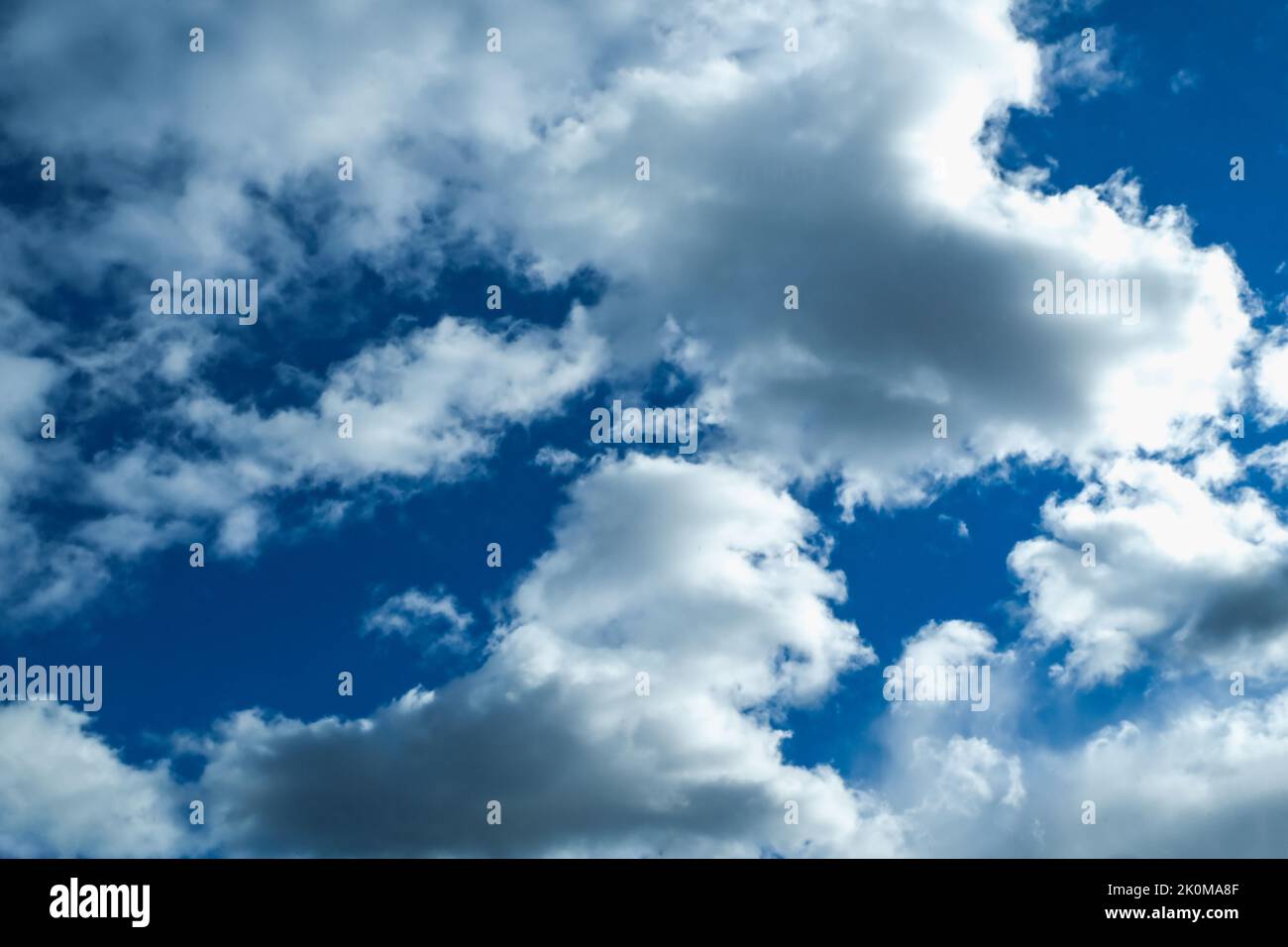 Blue sky with thunderclouds. The sun breaks through the clouds. Black clouds. Stock Photo