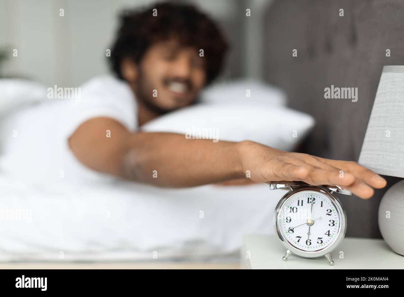 Hand turning off alarm clock waking up in the morning Stock Photo