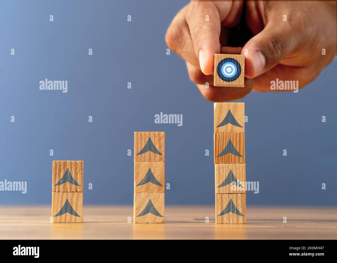 Close up photo of stacked wooden blocks with target icon as a symbol of