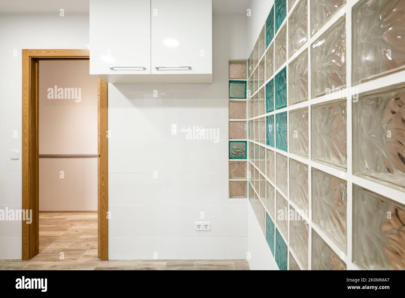fitted kitchen with white glossy wood and skylight wall with