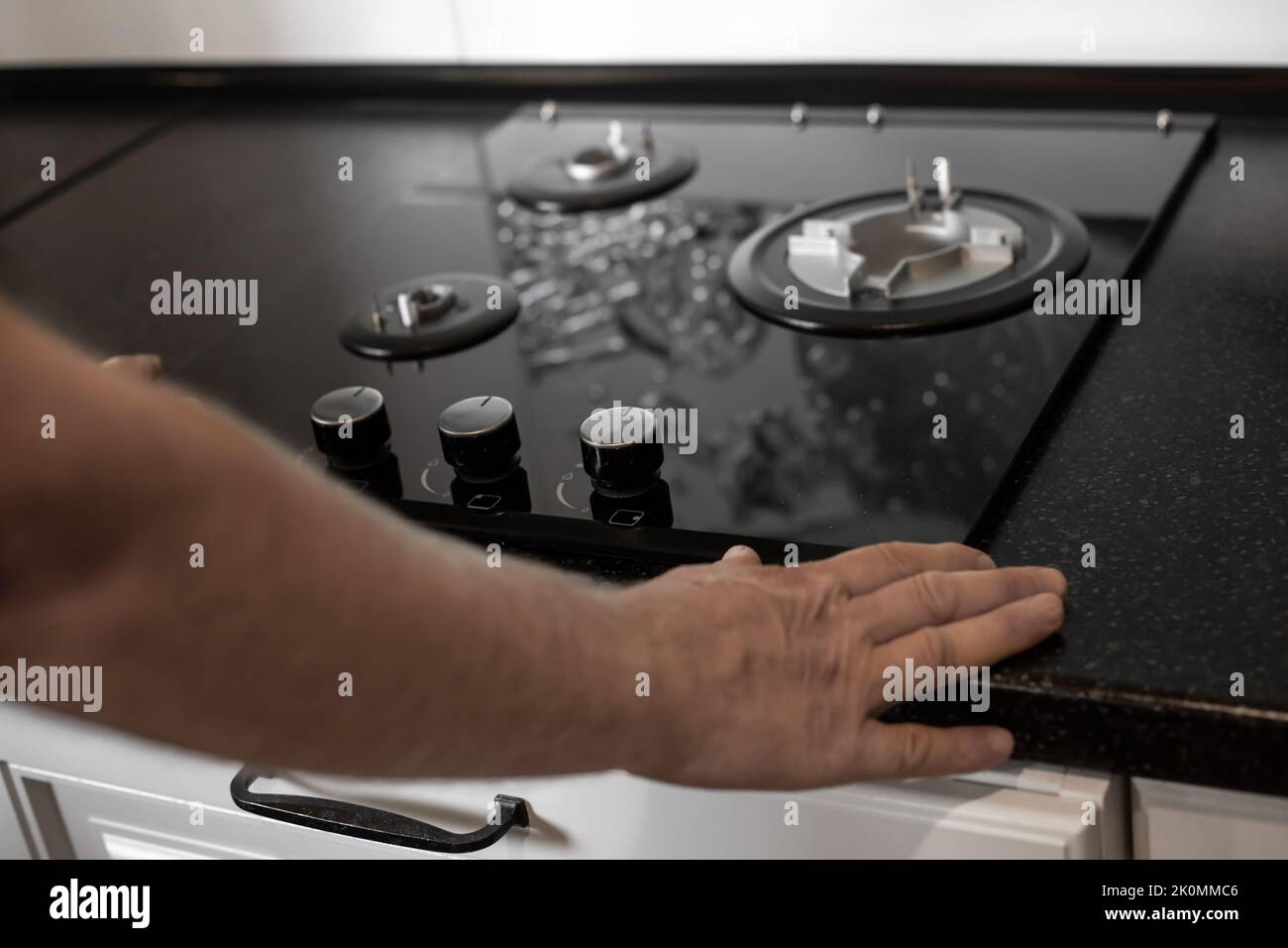 Installation of a gas threeburner builtin stove in a black countertop