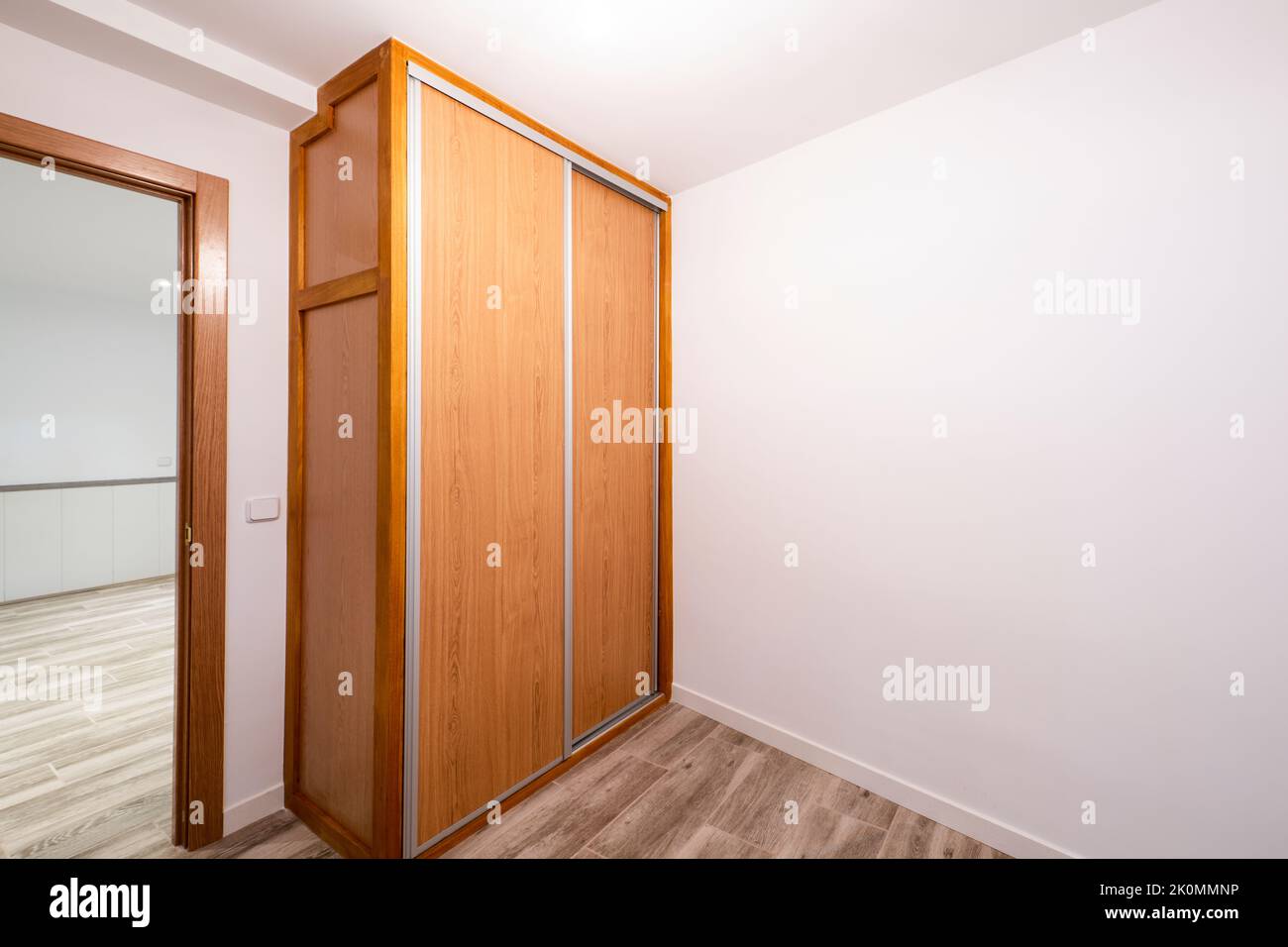 Renovated room with builtin wardrobe with sliding doors in cherry wood