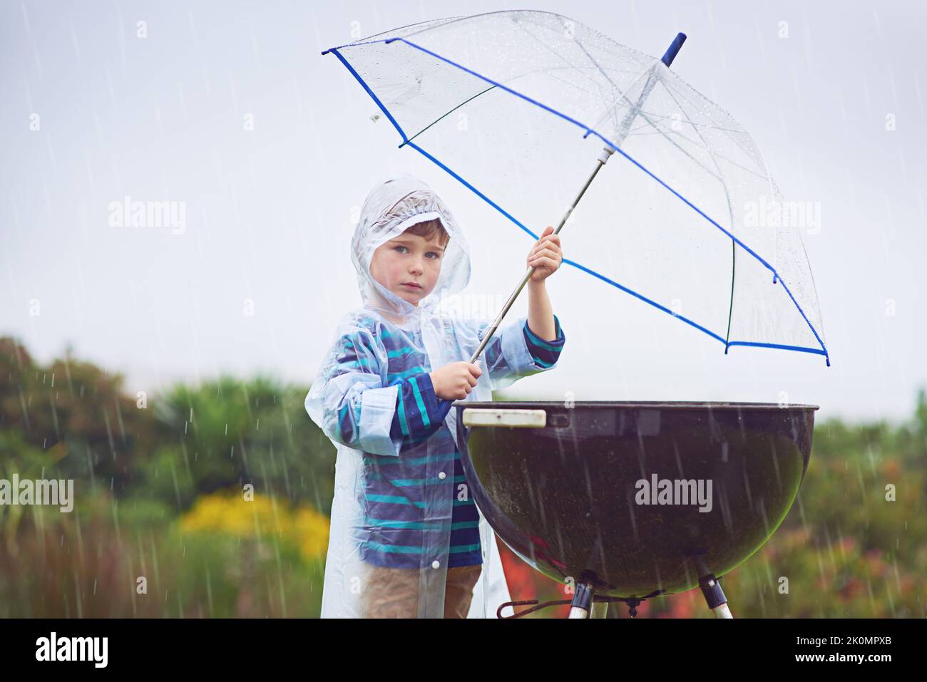 Trying to keep the grill dry. Cropped portrait of a young boy standing