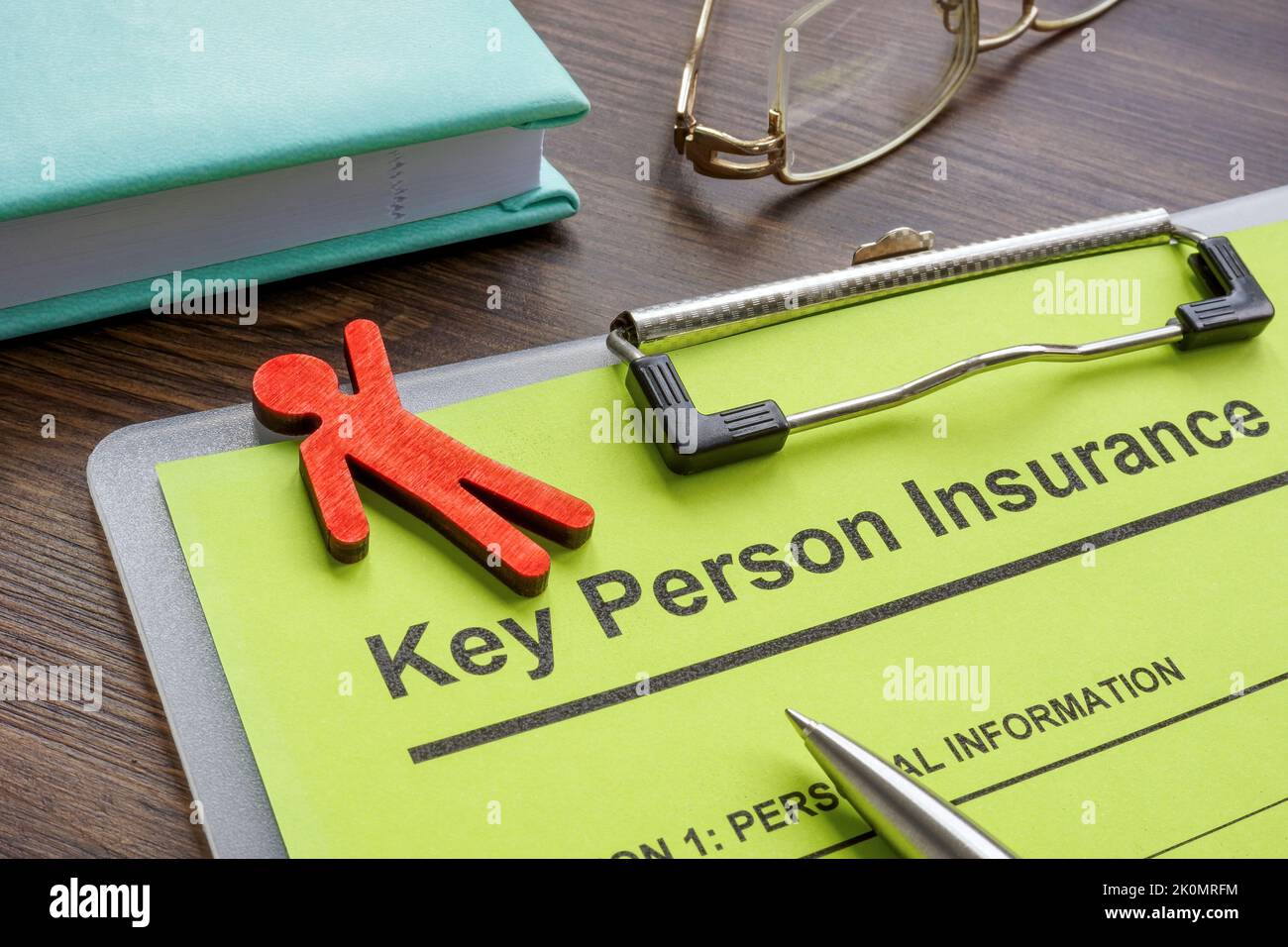 Key person insurance application and wooden figurine. Stock Photo