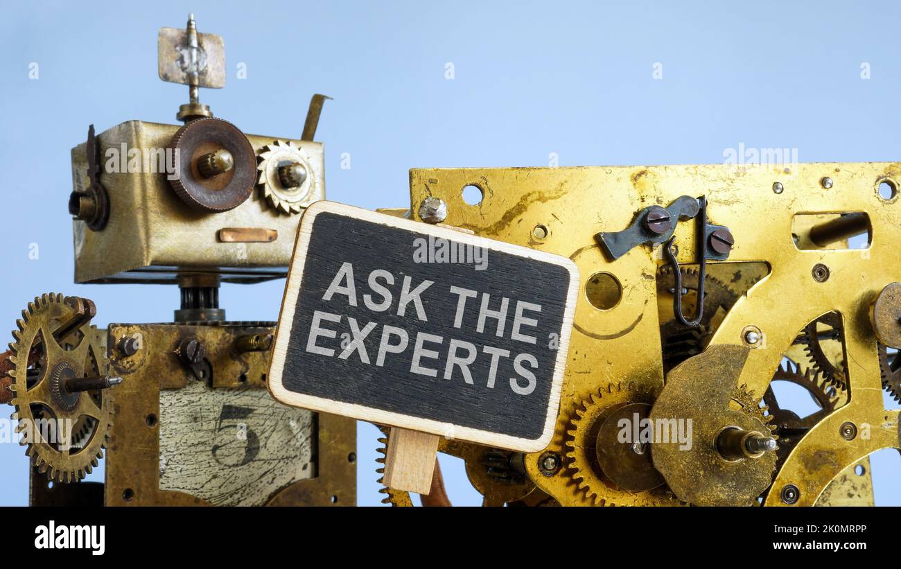 Robot with cog wheel holds plate Ask the experts. Stock Photo