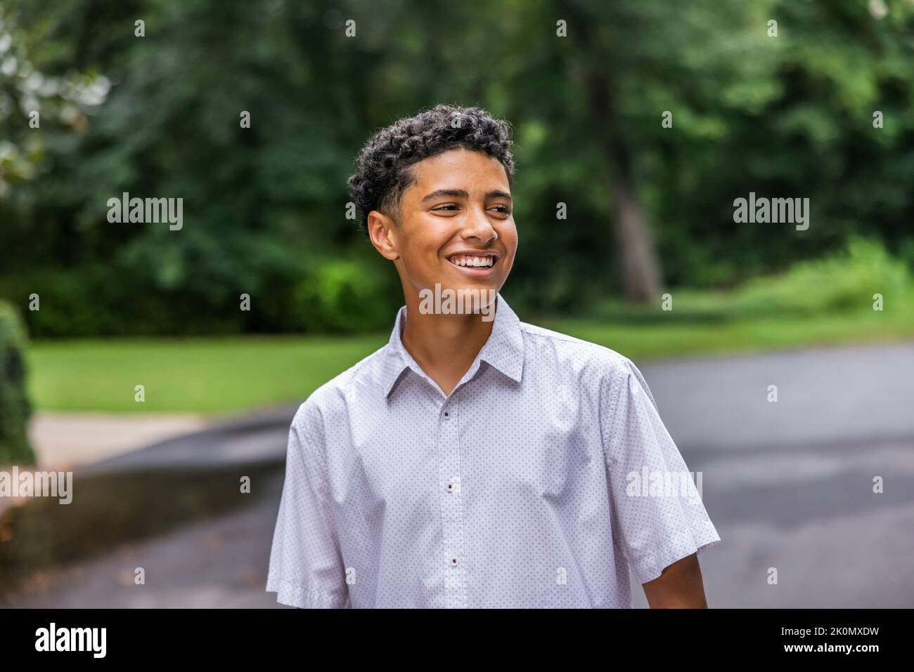 A close up image of a handsome teenage guy laughing and looking away. Stock Photo